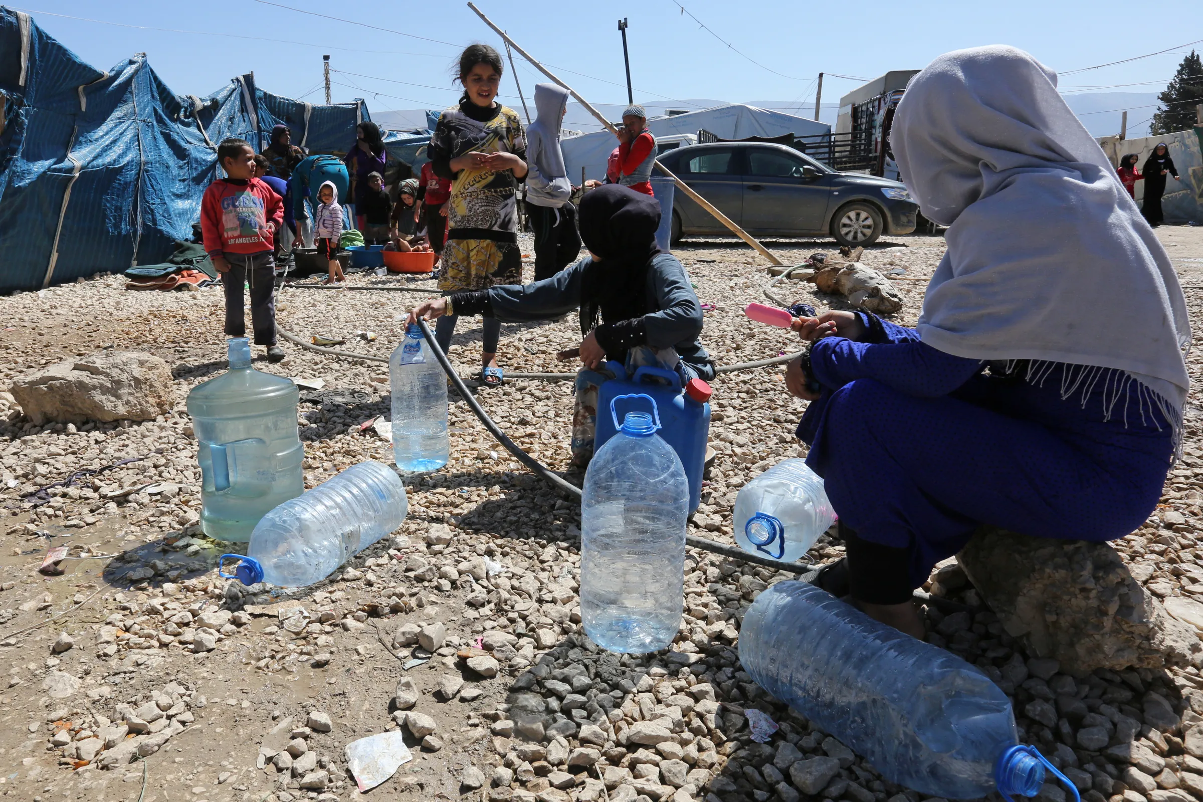 Syrian refugees fill containers and bottles with water at a makeshift settlement in Bar Elias town, in the Bekaa valley, Lebanon March 28, 2017