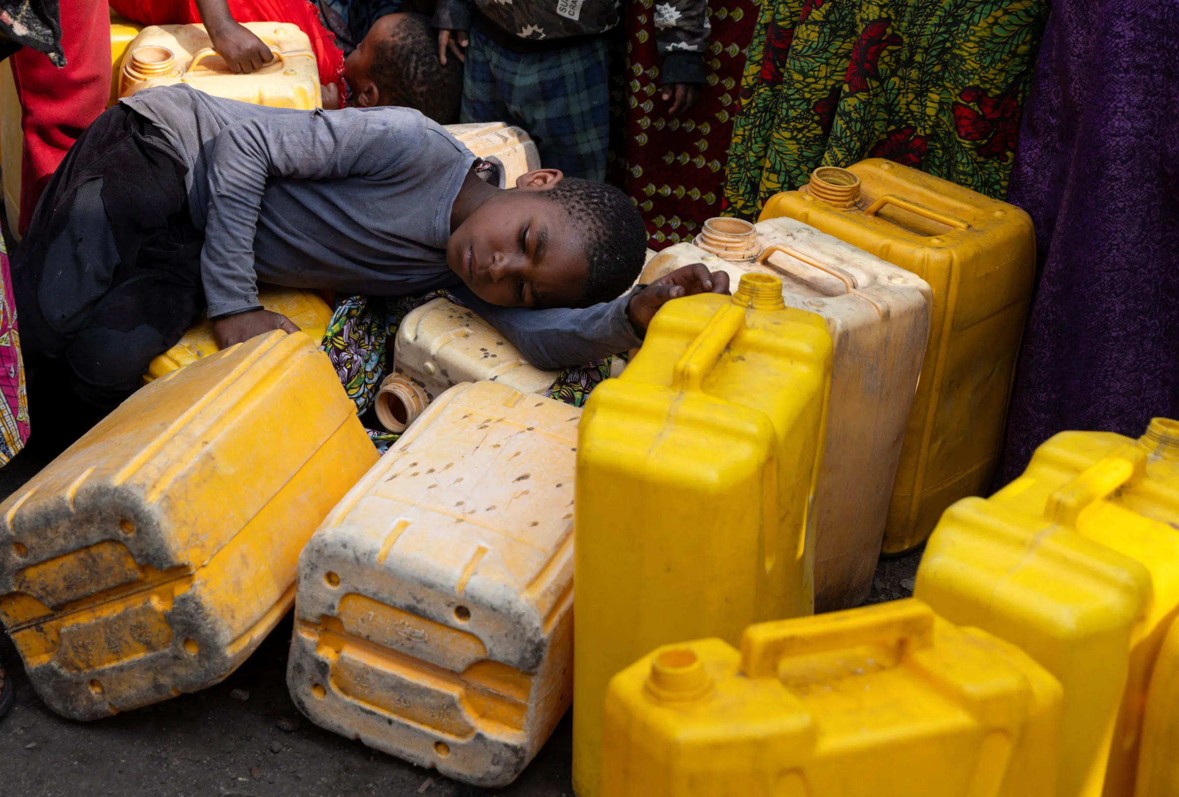 A child sleeps on plastic jerrycans, where incomplete water connections caused by USAID funding cuts have led to ongoing water shortages, in Goma, North Kivu province, Democratic Republic of Congo, June 16, 2025. REUTERS/Arlette Bashizi