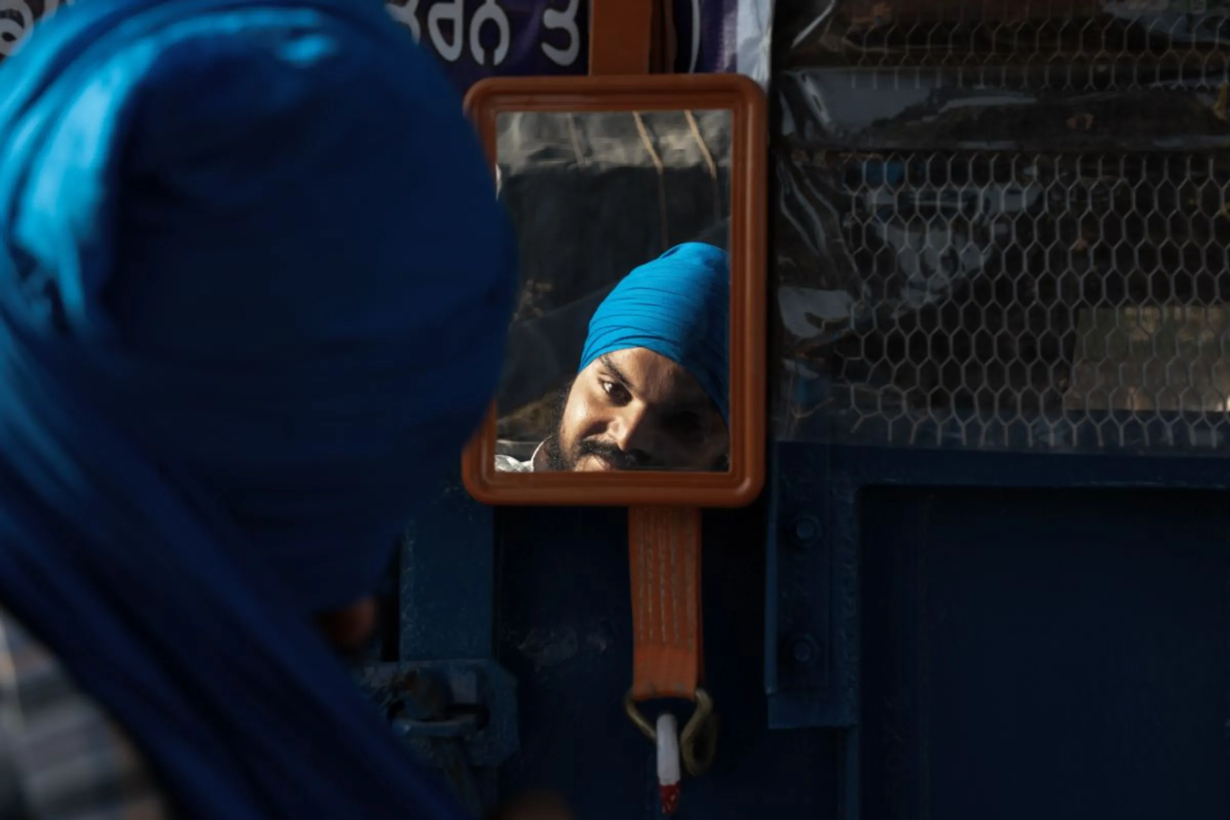 Hardeep Singh, a protesting farmer who suffered injuries to his right eye in clashes with police, fixes his turban in a mirror at Shambhu Barrier, India, February 22th, 2024. Thomson Reuters Foundation/Mehran Firdous