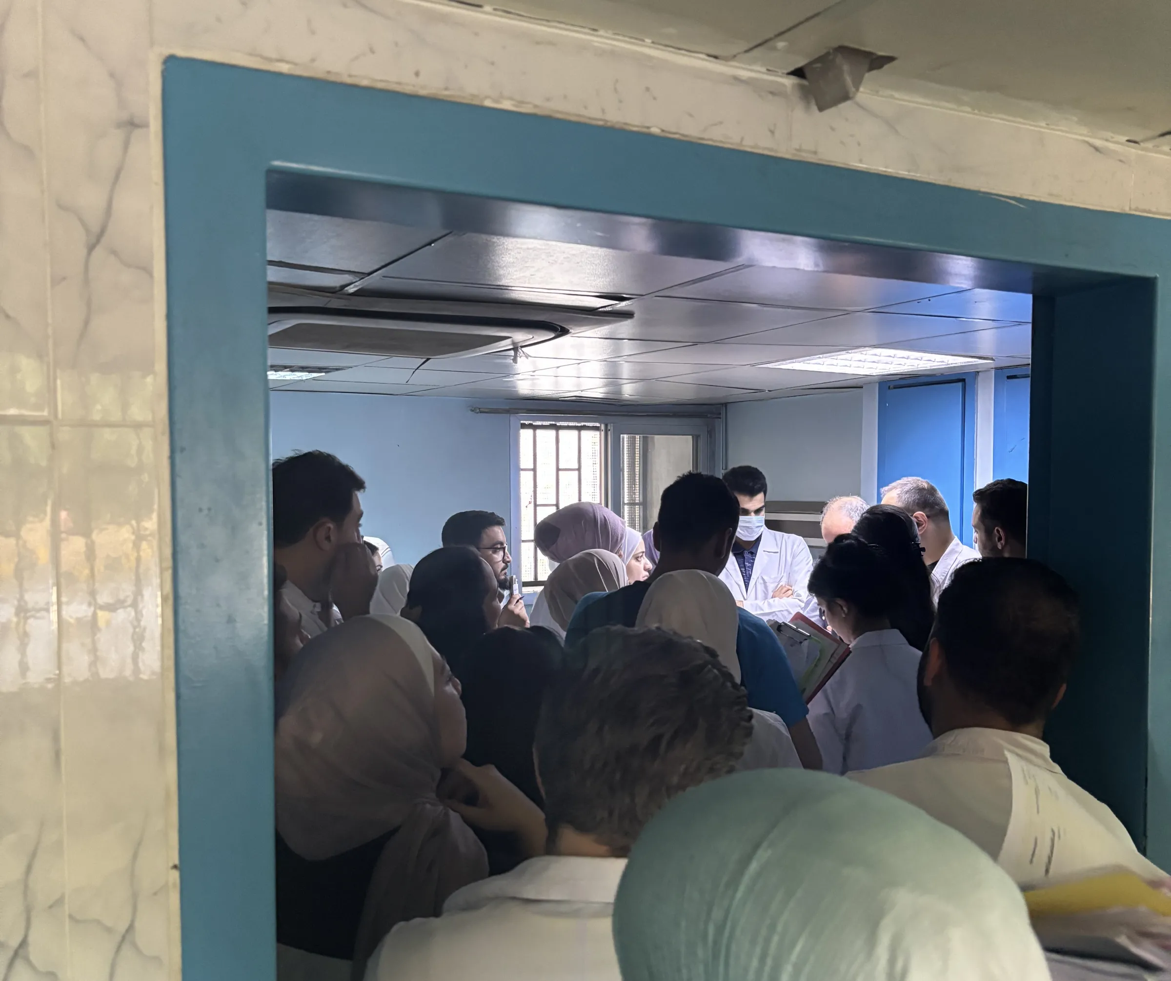 Trainee doctors spill out of a patient's room as Dr. Bashar Hamad leads rounds at the Al Mojtahed public hospital in Damascus. Damascus, Syria, May 21, 2025. Thomson Reuters Foundation/Nazih Osseiran