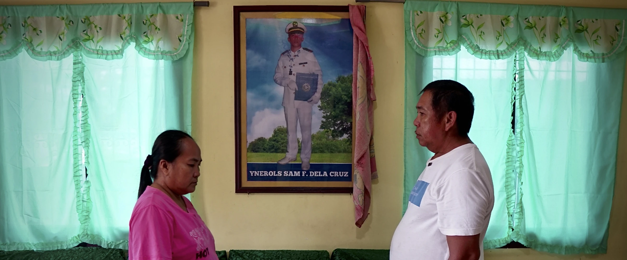 Sam Dela Cruz’s parents, Rosalyn and Samson, show their late son’s photo at the center of their living room. Sultan Kudarat, Philippines, June 4, 2025. Thomson Reuters Foundation/Raizza Bello