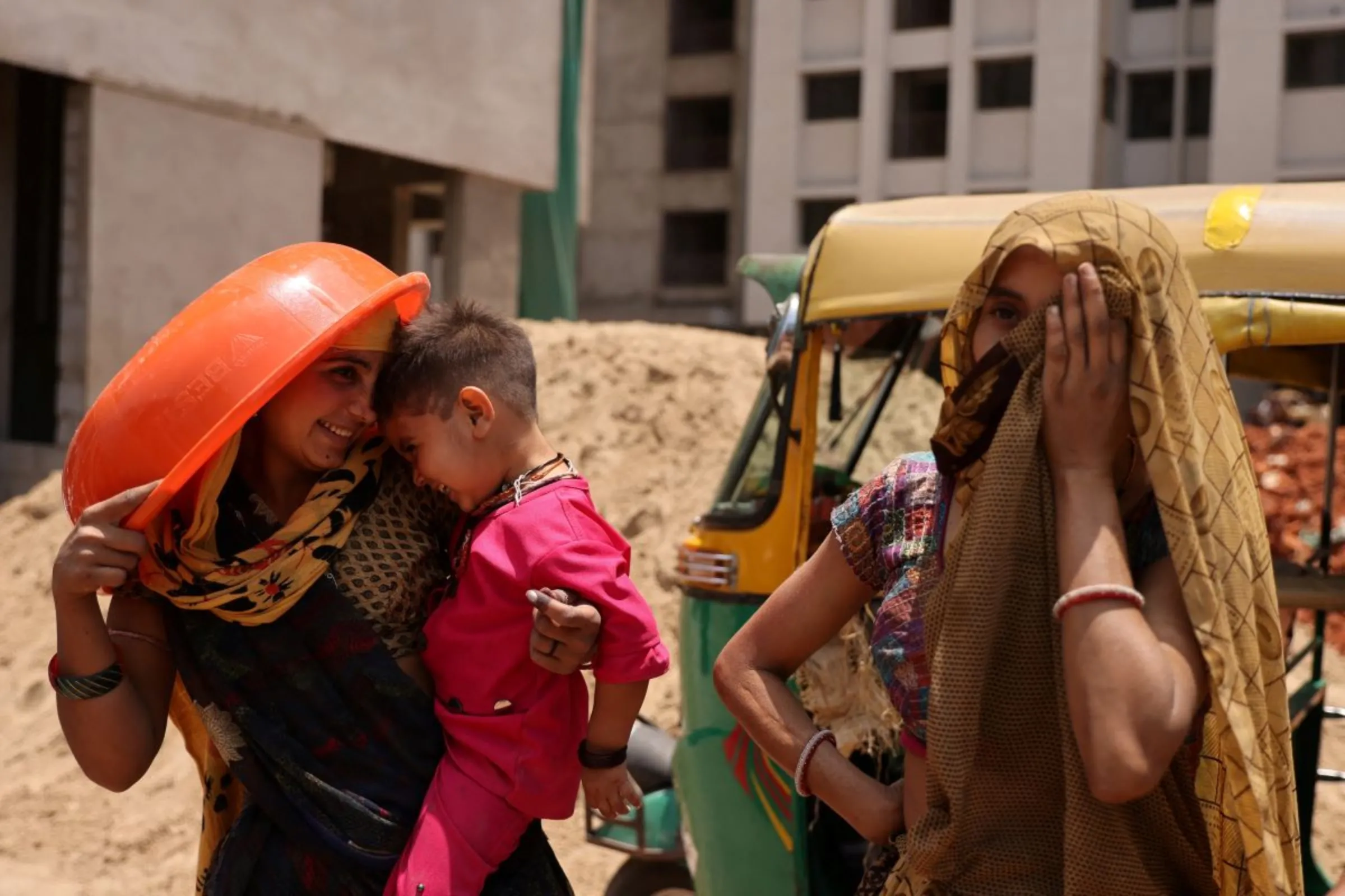 Women take shelter from the sun at a construction site in Ahmedabad, India, April 28, 2023