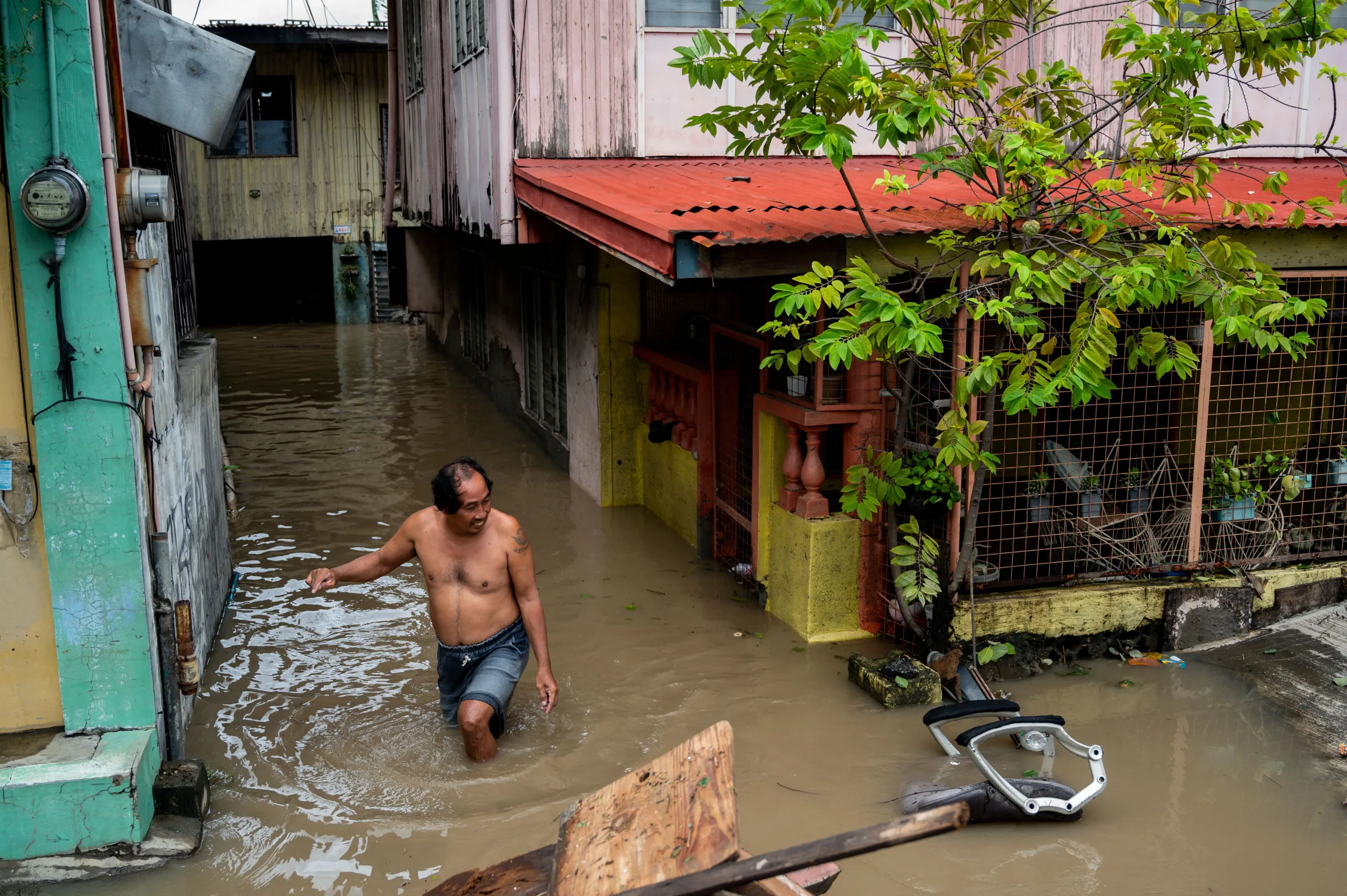 A man wades through a flooded street following heavy rains brought by Tropical Storm Nalgae, in Kawit, Cavite province, Philippines, October 30, 2022. REUTERS/Lisa Marie David