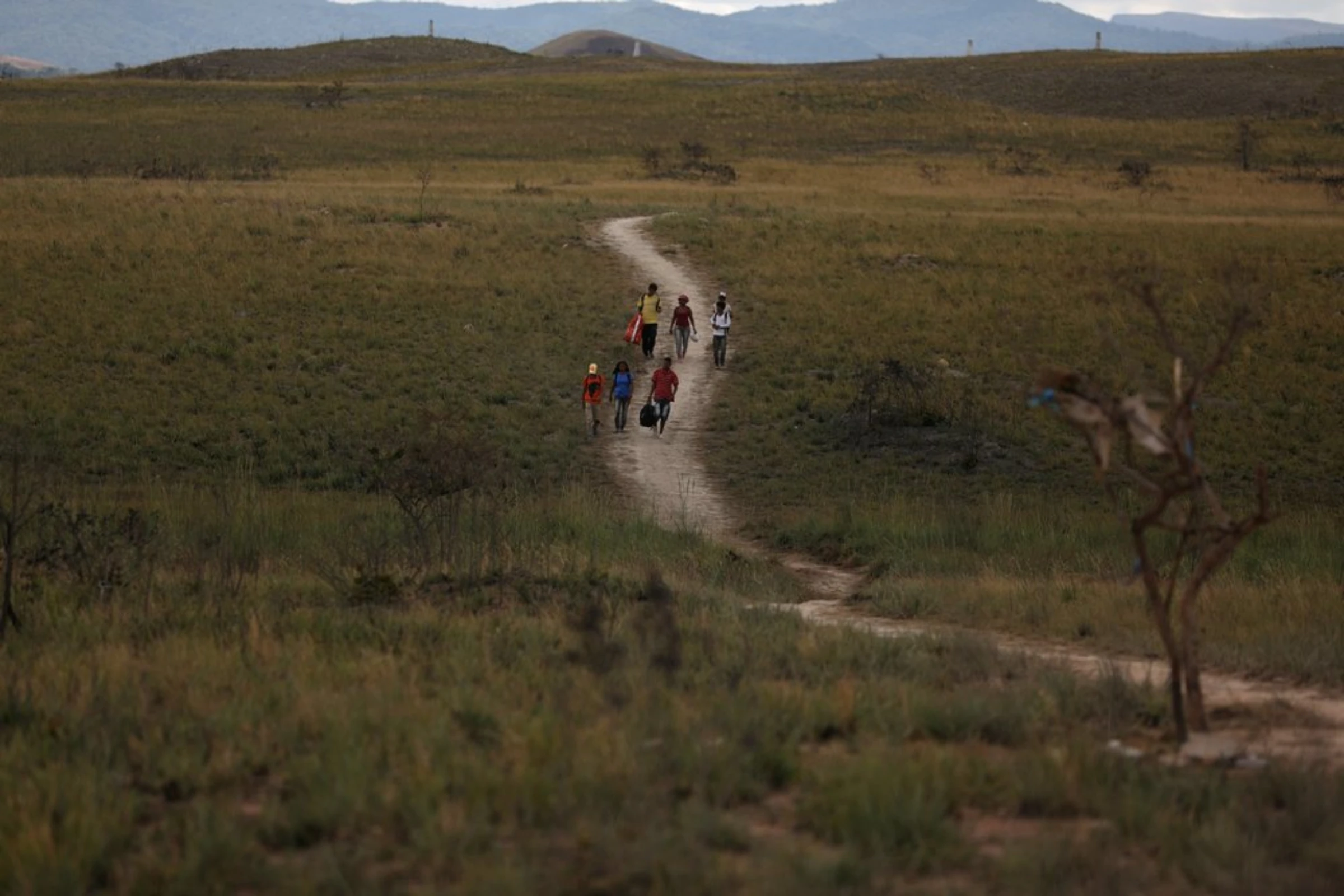 Venezuelans walk along a trail into Brazil, at the border city of Pacaraima, Brazil, April 13, 2019