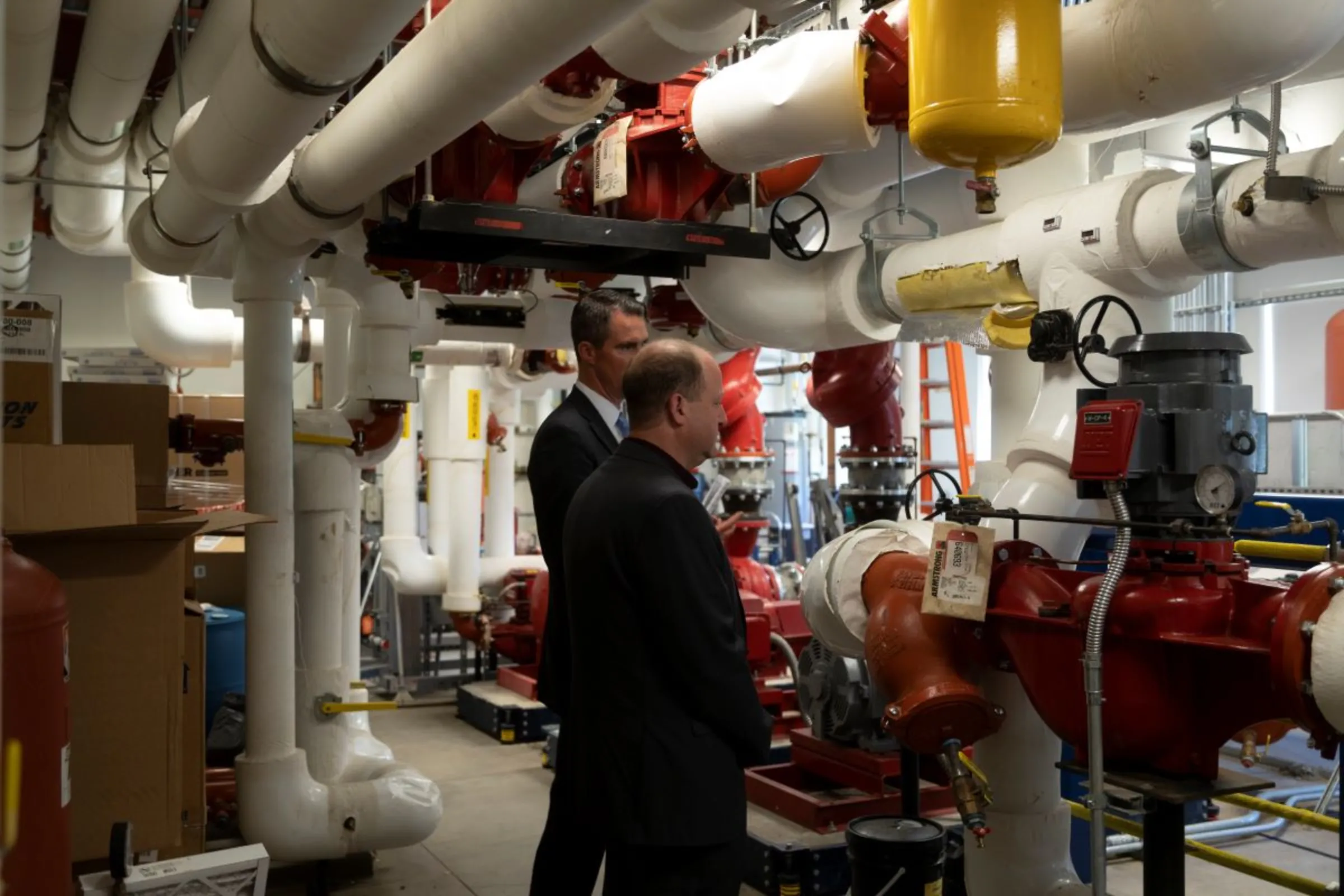 Colorado Mesa University John Marshall, left, talks with Colorado Governor Jared Polis about the school’s geo-exchange heating and cooling system on September 27, 2022, in Grand Junction, Colorado. Colorado Mesa University/Handout via Thomson Reuters Foundation