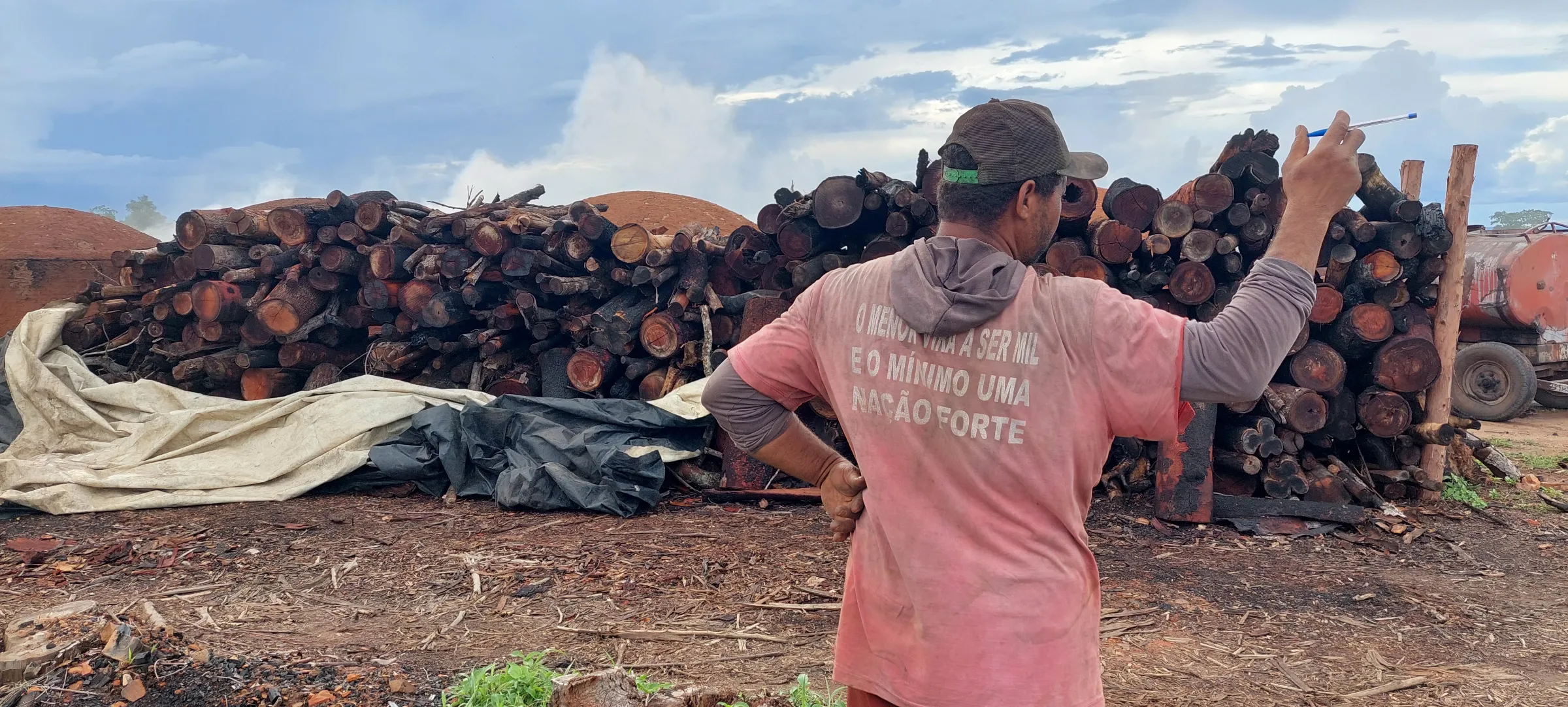 A charcoal producer shows the stockpile of native Cerrado trees that were to be burned to produce charcoal in Brazil. December 6th, 2021. Thomson Reuters Foundation/Fabio Teixeira