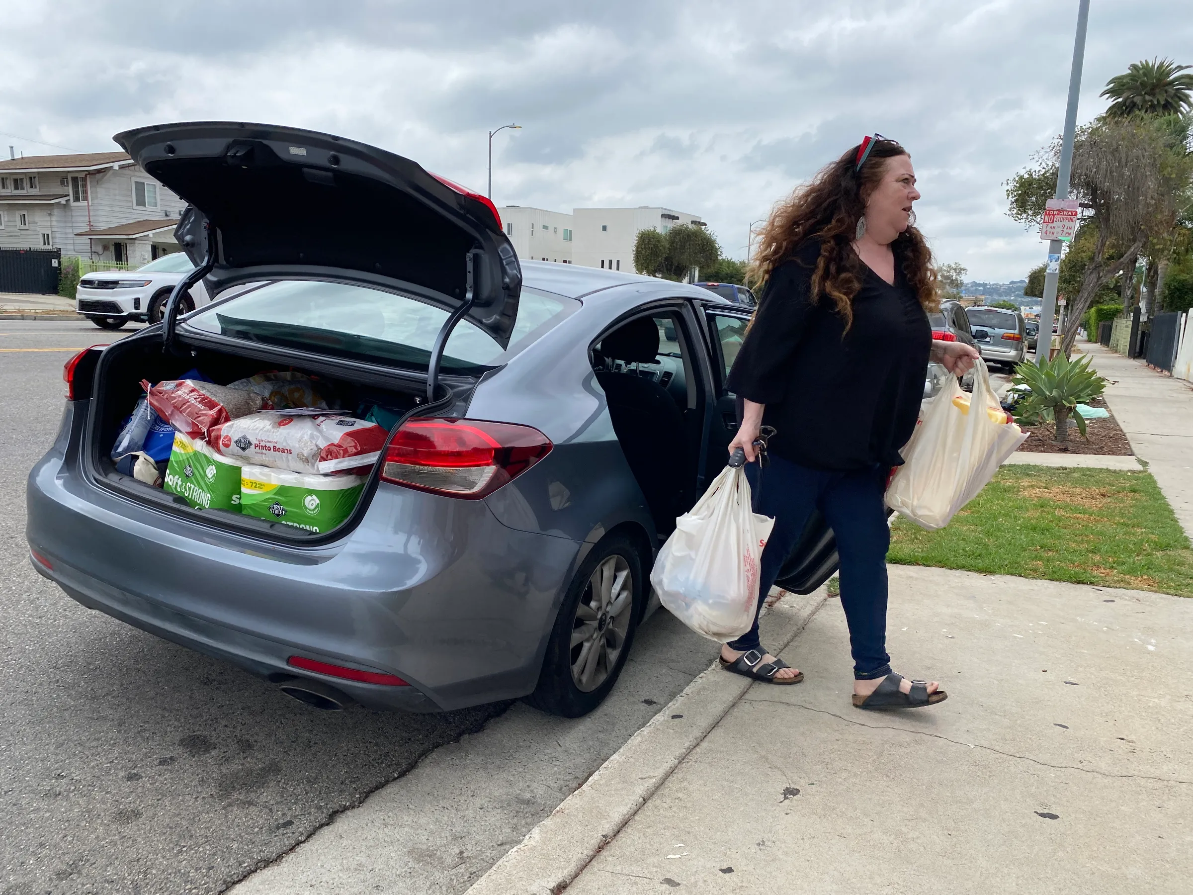 Kelly Flores, a school teacher, drops off basic groceries and household necessities at her first stop of the day.  Los Angeles, U.S., July 22, 2025. Thomson Reuters Foundation/Rachel Parsons