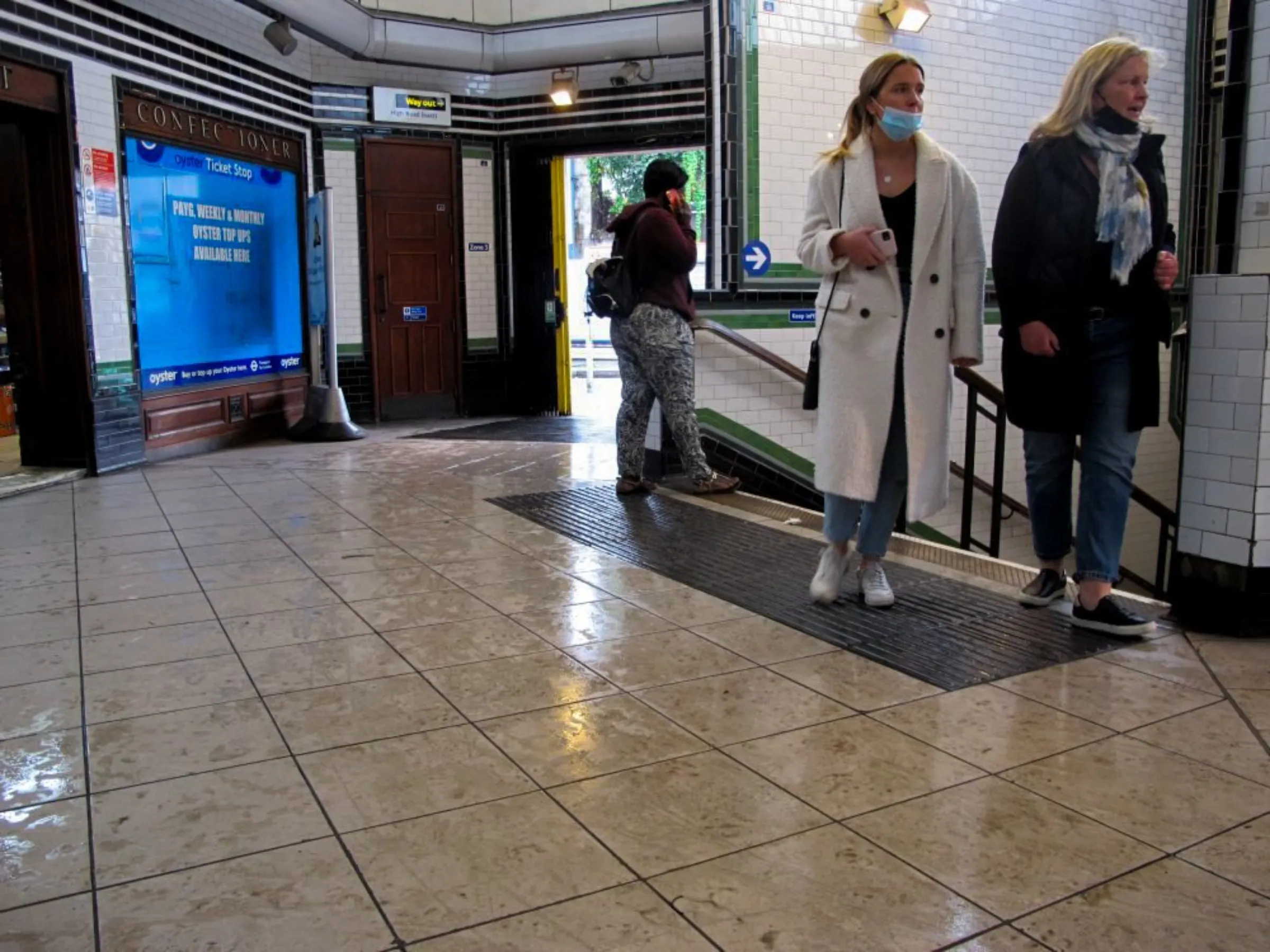 Northern Line commuters walk through a wet Balham Station in south London, England, after rain on October 18, 2021