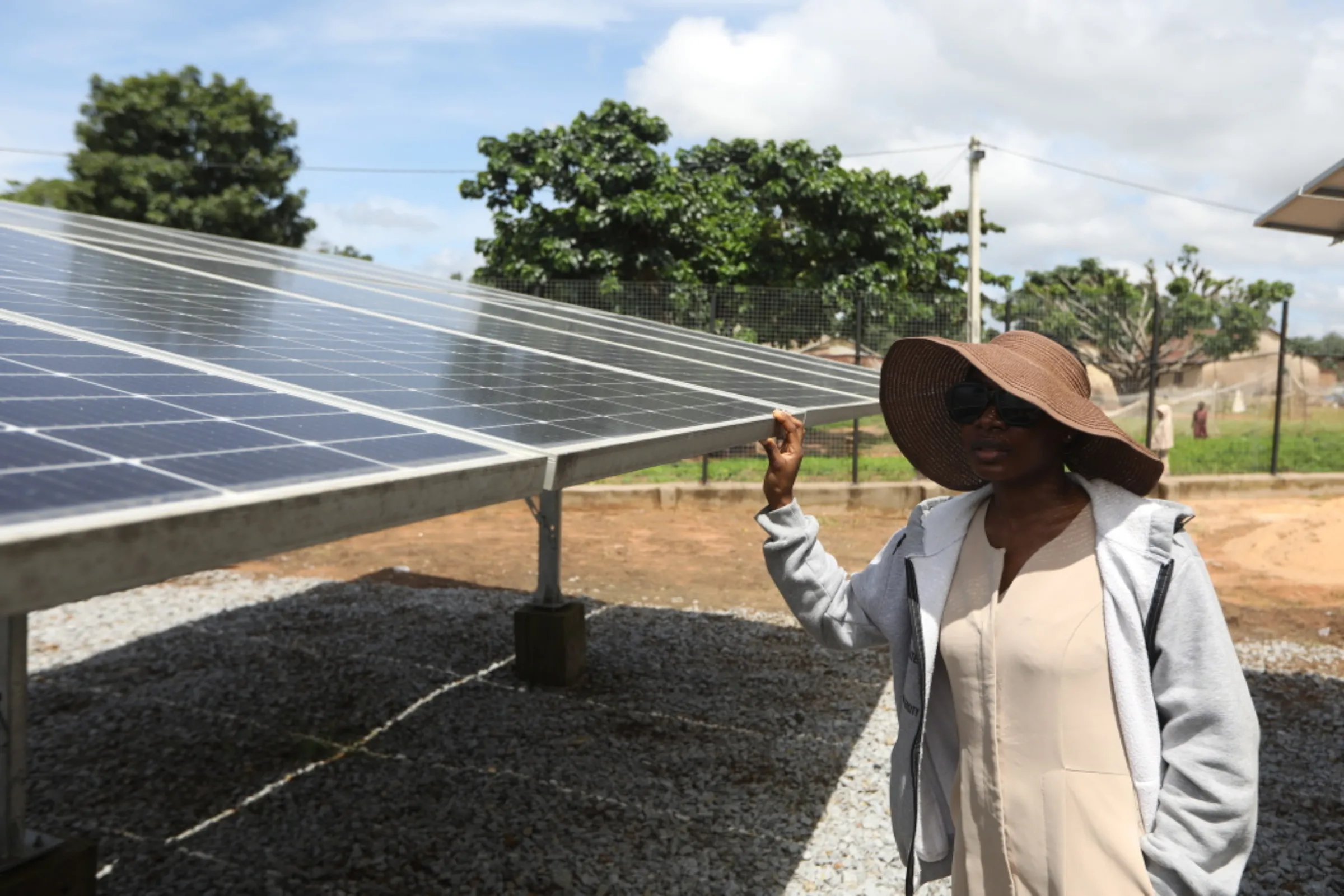 Jennifer Anya, renewable energy operations manager for Husk Power, inspects solar panels at the company's minigrid in Kiguna, Nasarawa, Nigeria, September 26, 2022. Thomson Reuters Foundation/Afolabi Sotunde