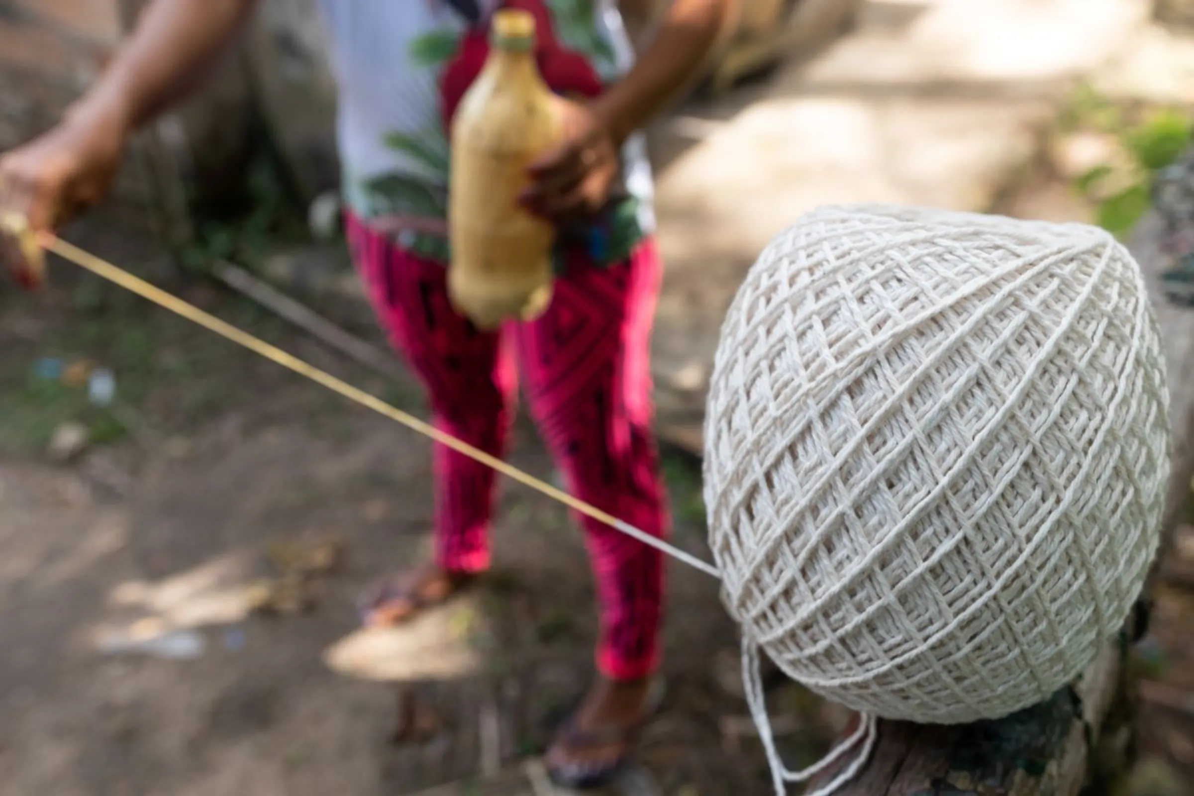 Corina Magno shows a ball of rubber thread near her home on the river island of Cotijuba in Pará, Brazil, January 17, 2023. Thomson Reuters Foundation/Cícero Pedrosa Neto