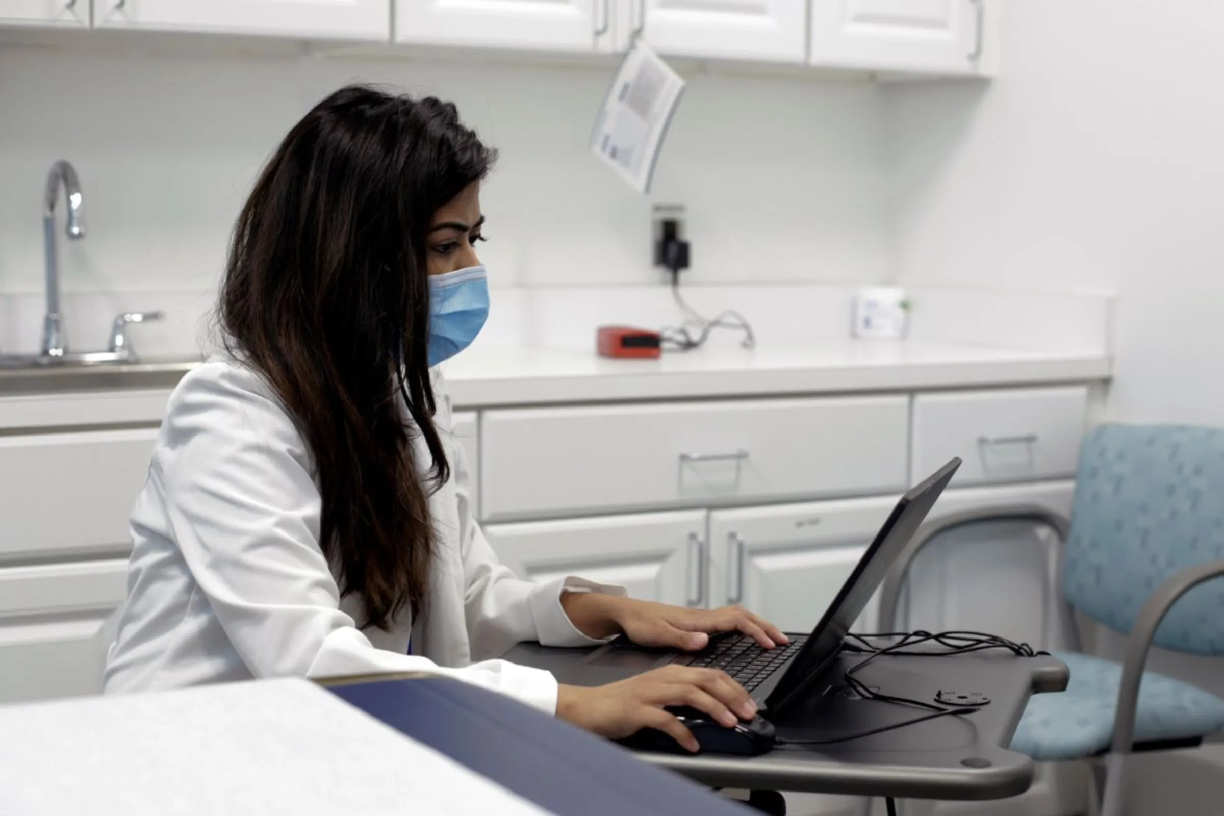 Dr. Meera Shah, the chief medical officer for Planned Parenthood Hudson Peconic, communicates with patients online in an unoccupied exam room in White Plains, New York, U.S., April 3, 2020. REUTERS/Liliana Engelbrecht