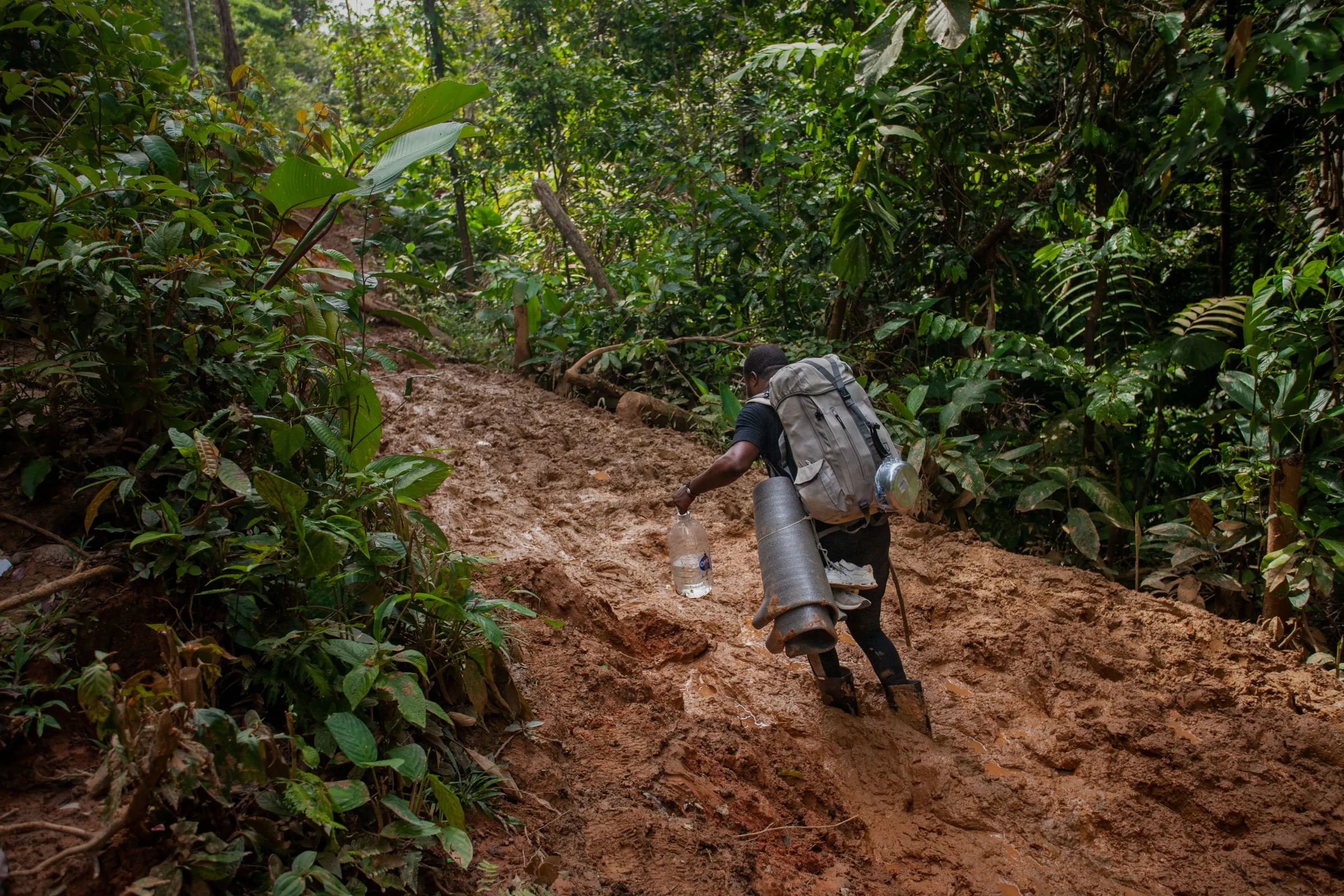 Congolese migrant Arnola, a former boxing champion, walks through the muddy trail in the Colombian jungle in the Darién Gap. Darién Gap, July 27, 2022. Thomson Reuters Foundation/Fabio Cuttica