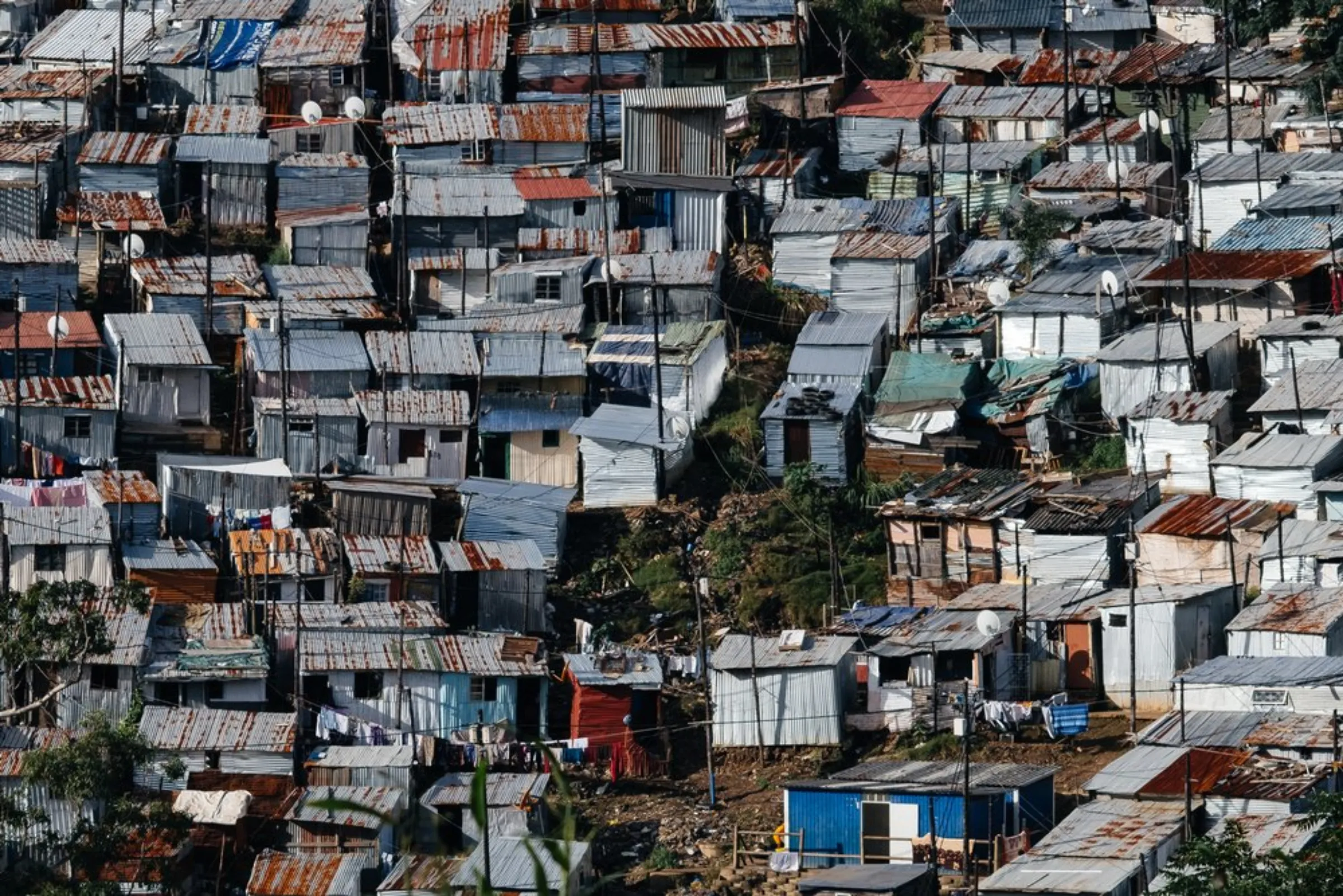 Densely packed shacks cover a steep hillslope at the Foreman Road informal settlement in Durban, South Africa, March 30, 2021. High population densities and a severe shortage of adequate housing and land has seen informal settlements established on spaces dangerous to inhabit, such as the steep slopes that characterise much of the city