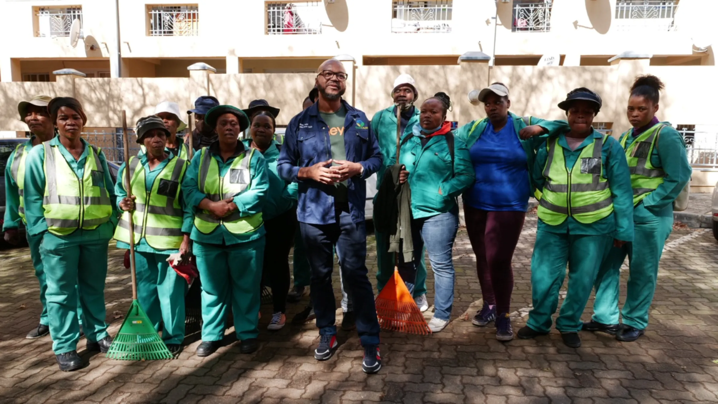 Dalu Cele, the founder of Clean City SA, stands in front of some of the cleaners he has helped train and employ with the presidential funding stimulus in inner-city Johannesburg, South Africa, May 10, 2023. Thomson Reuters Foundation/ Kim Harrisberg