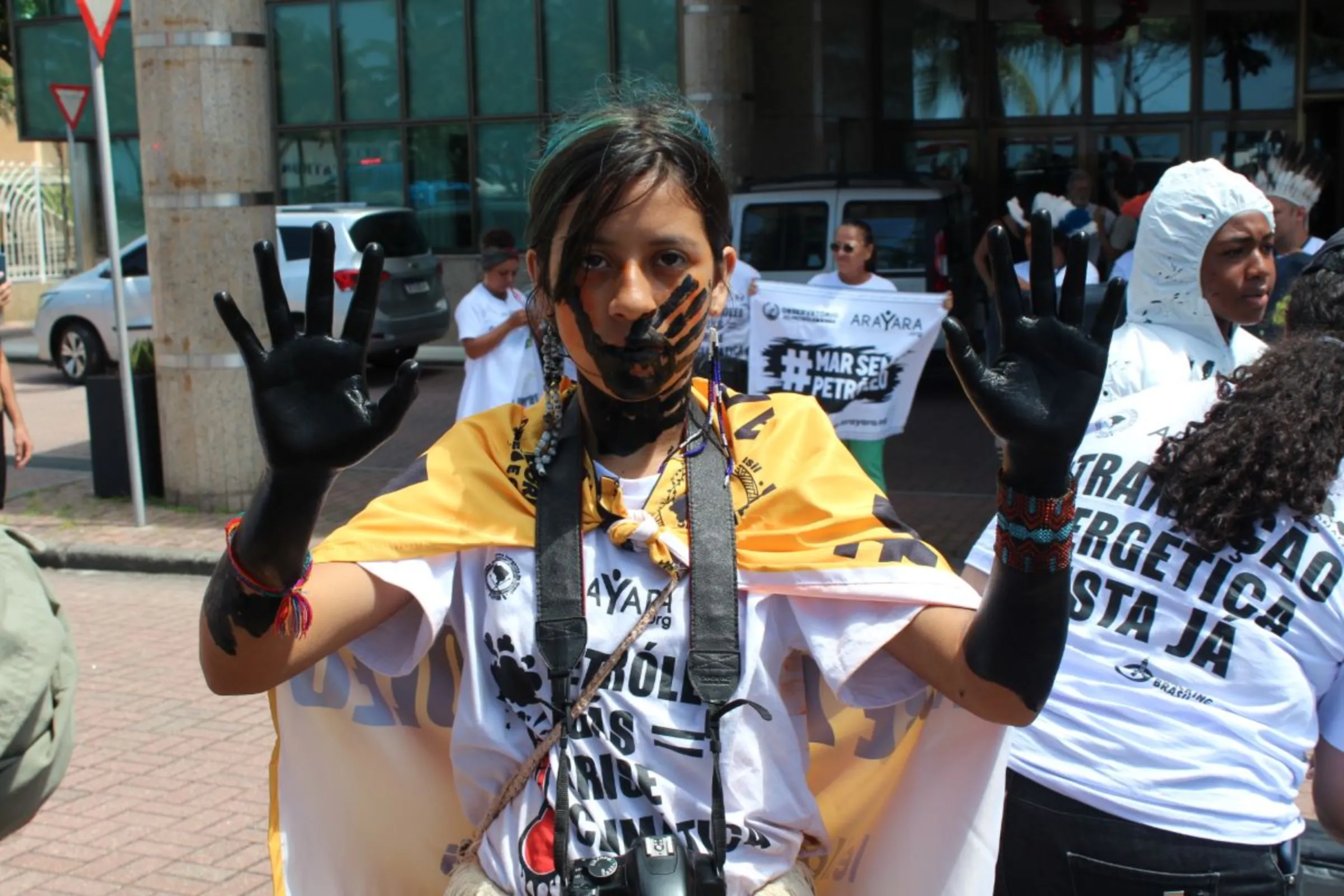 A protester shows their hands painted black in front of the hotel where Brazil’s government held an auction for oil and gas concession areas in Rio de Janeiro on Dec. 13, 2023. Thomson Reuters Foundation /André Cabette Fábio