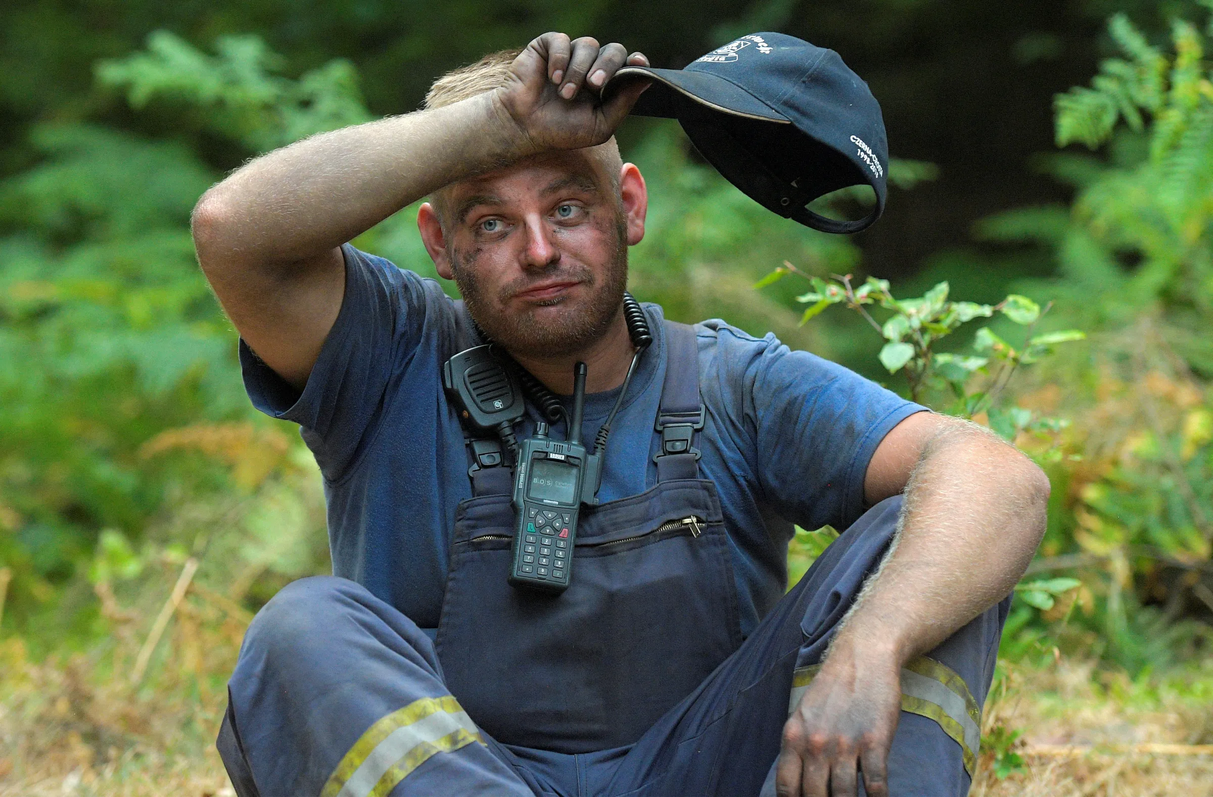 Firefighter Fabian Tzscharnke takes a break as he helps to extinguish a forest fire during a heatwave close to the German-Czech border