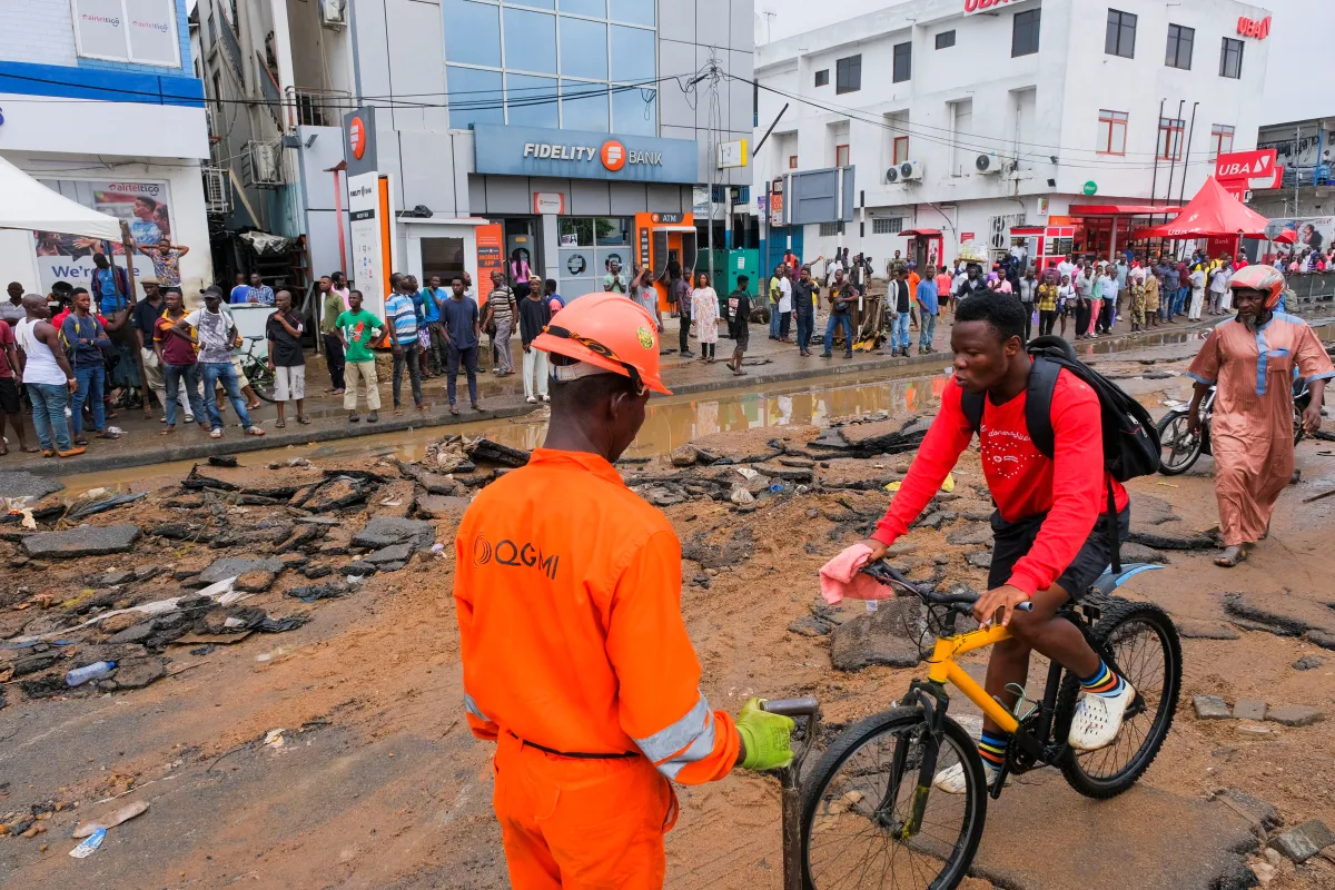 People observe a stretch of road destroyed by flooding in Accra, Ghana May 24, 2022. REUTERS/Francis Kokoroko