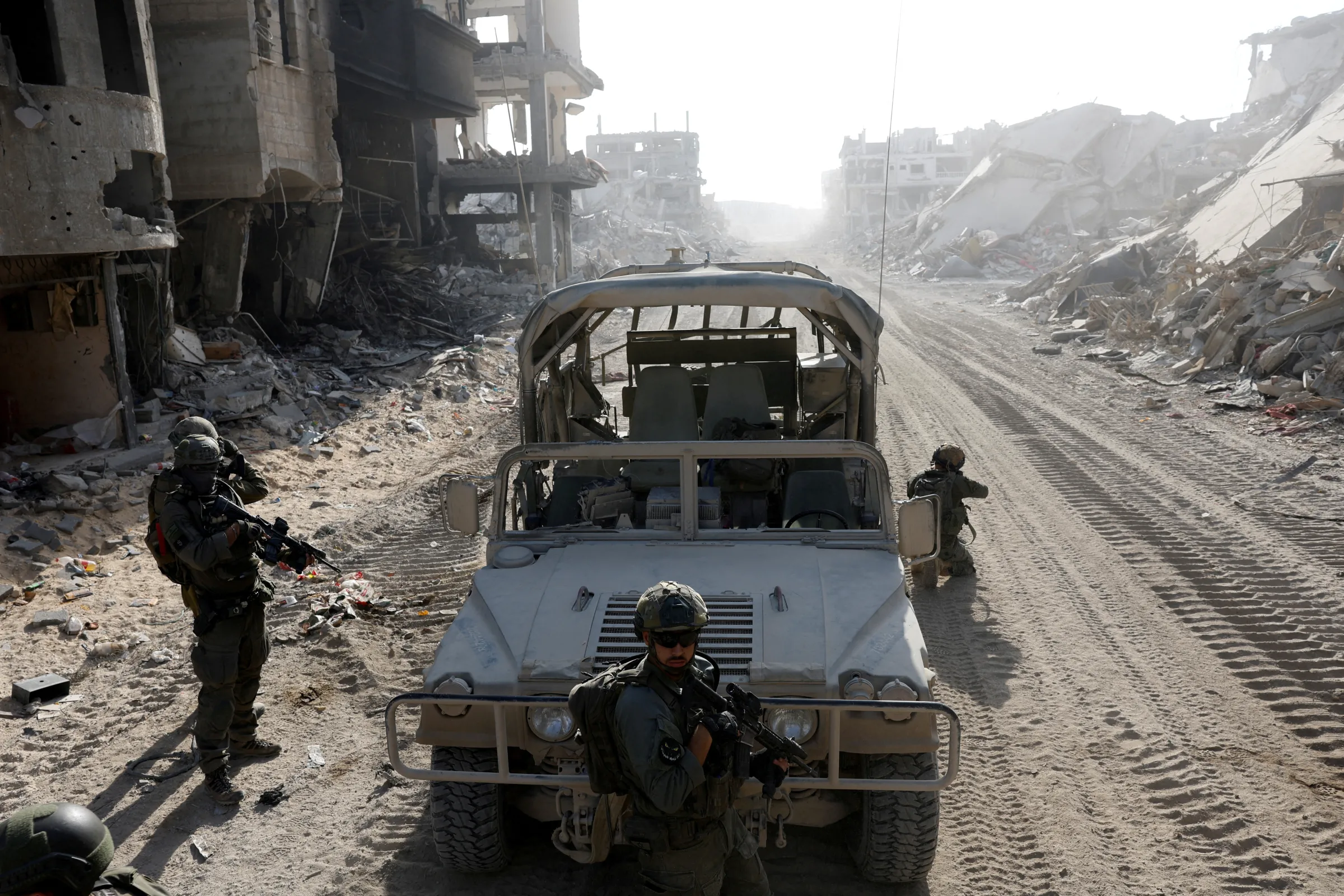 Soldiers hold weapons near a military vehicle amid the ongoing ground operation of the Israeli army against Palestinian Islamist group Hamas, in the Gaza Strip, September 13, 2024. REUTERS/Amir Cohen