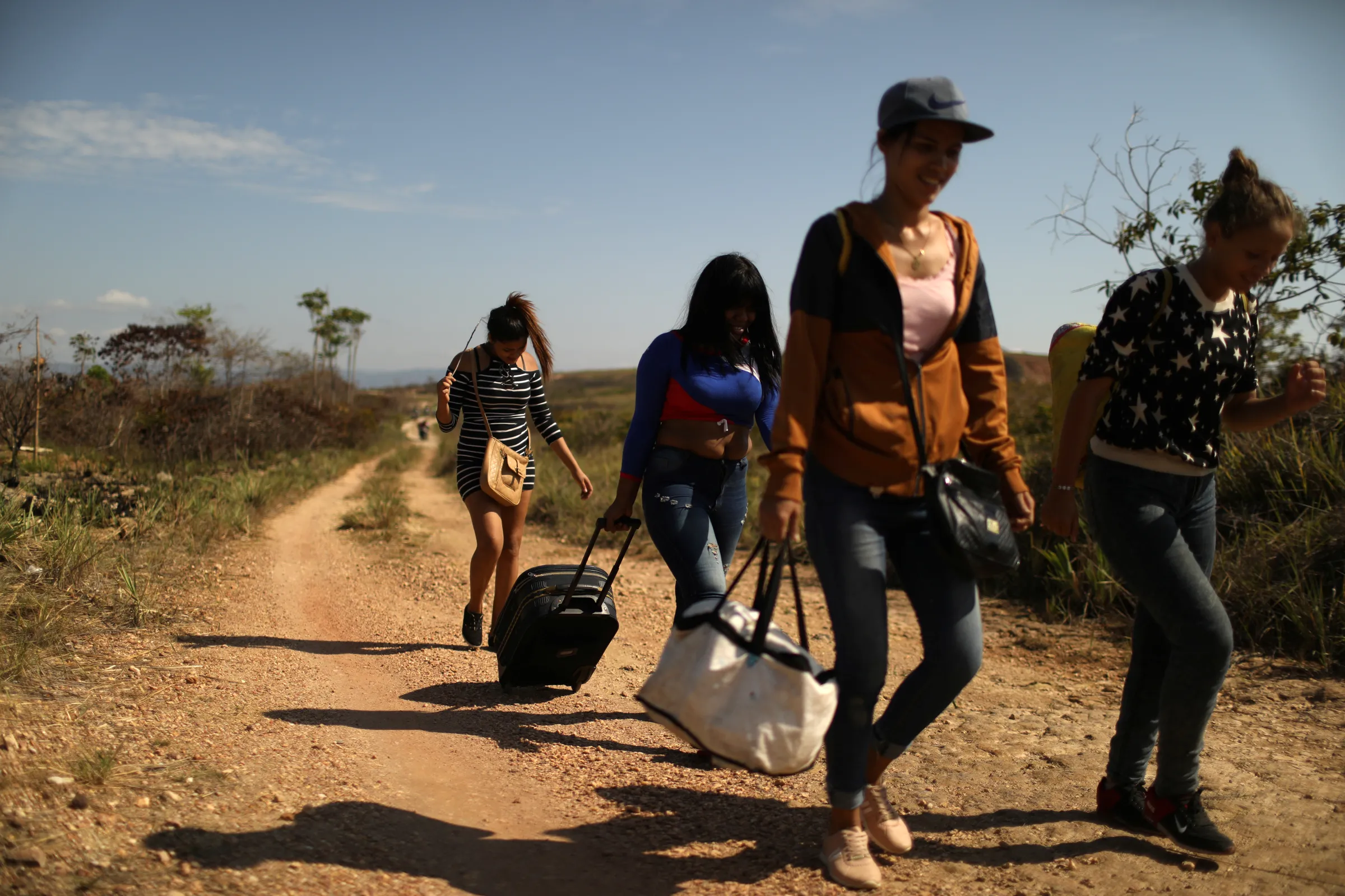 Venezuelan migrants walk along a trail into Brazil
