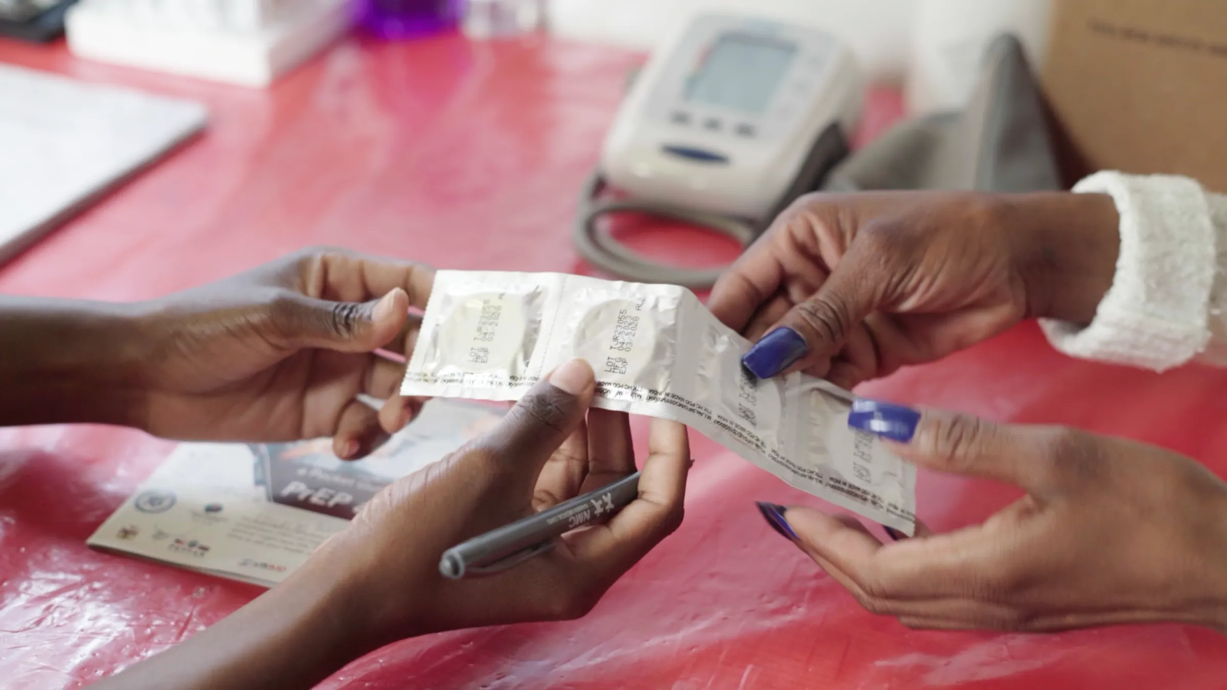 A nurse from the Walvis Bay Corridor Group (WBCG) gives condoms to a trans woman visiting one of their clinics in Walvis Bay, Namibia, in November 2024. Lila Swanopoel/Thomson Reuters Foundation