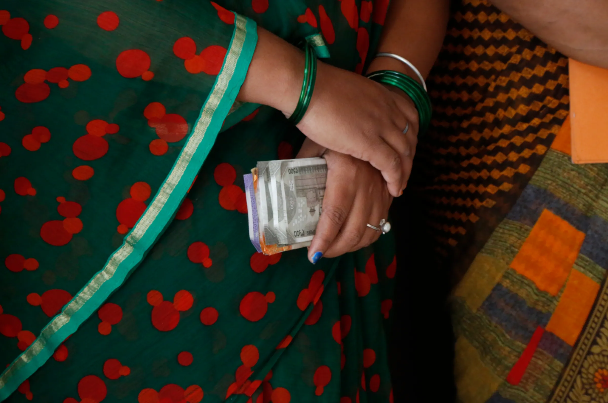 A woman borrower holds cash in her hand during a loan installment collection in her village in Sakri, Madhya Pradesh, November 10, 2022