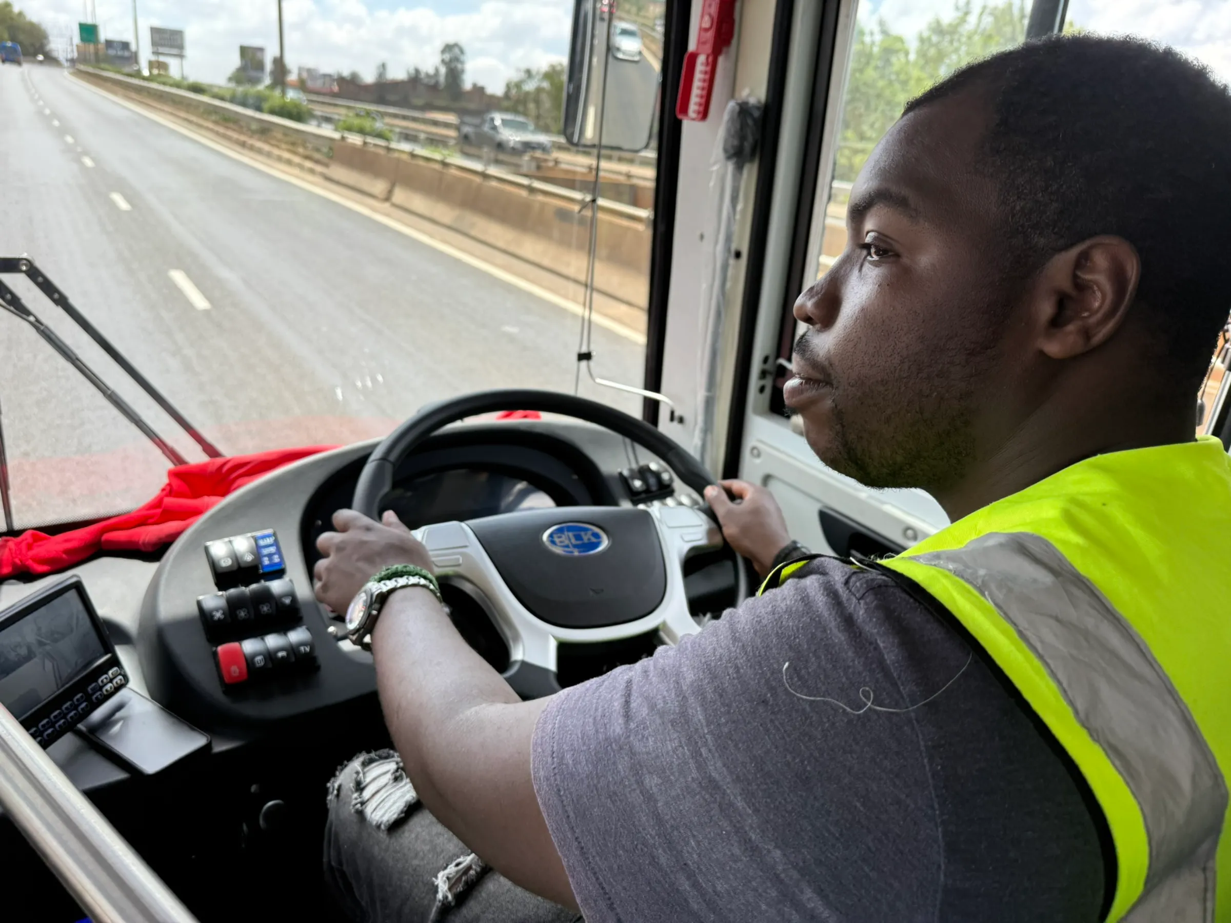 A driver for Kenyan electric bus firm BasiGo drives a newly assembled bus in Nairobi, Kenya on Nov. 5, 2024.  Thomson Reuters Foundation/Nita Bhalla