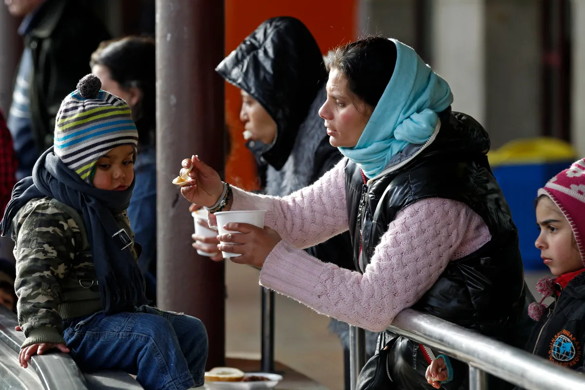 A woman feeds her child during an event organised by the British embassy to Romania, Bucharest townhall and various non-governmental organisations (NGOs) in Bucharest December 11, 2013. Hot meals are offered to the poor and the homeless during the annual event in an effort to raise awareness to their increasing number in the European Union's second poorest country
