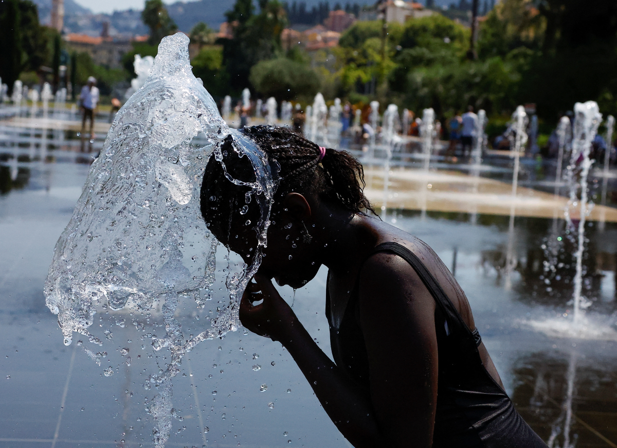 A girl cools off in a fountain in Nice as a heat wave hits France