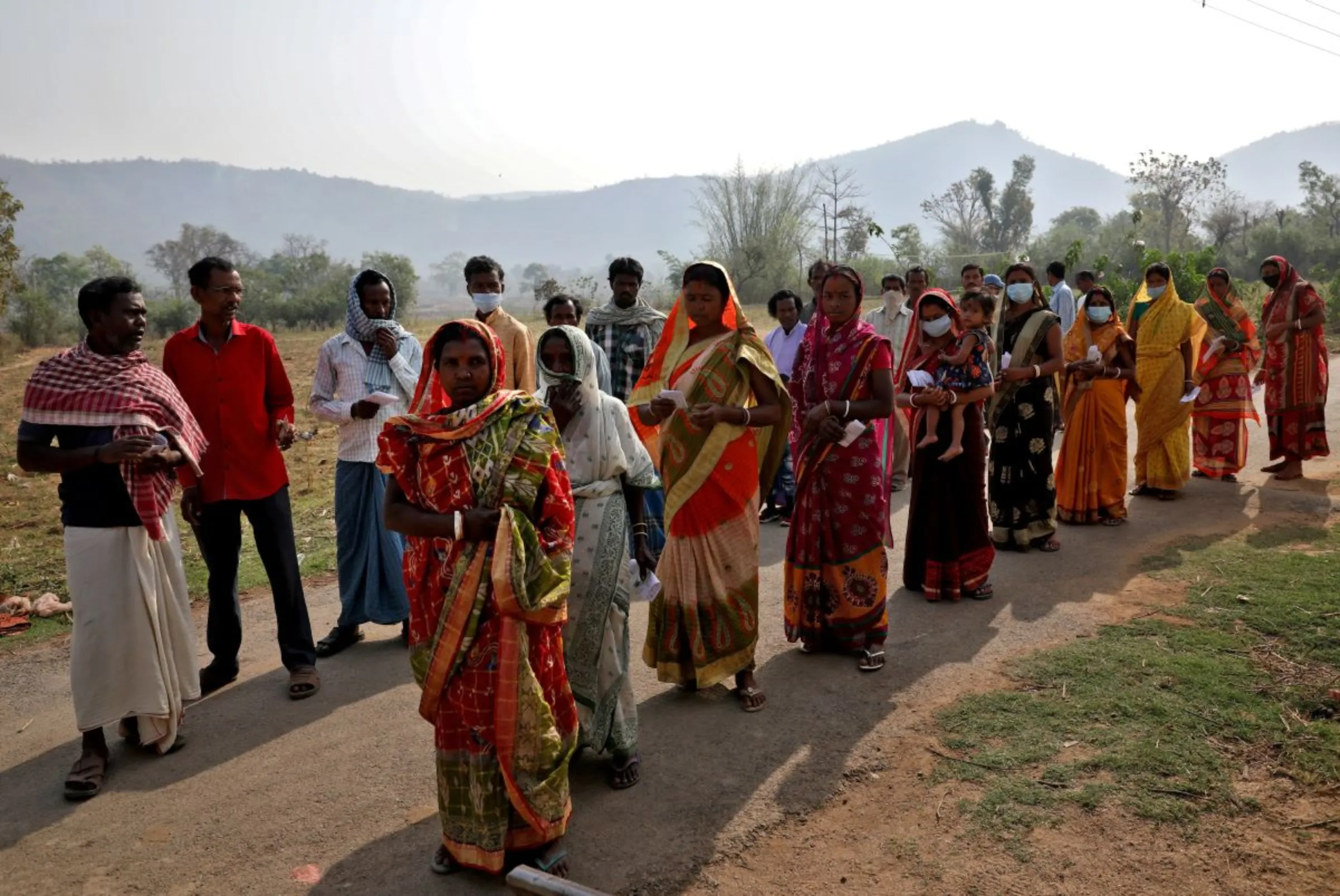 People wait in lines to cast their vote outside a polling station in the Purulia district, India, March 27, 2021. REUTERS/Rupak De Chowdhuri