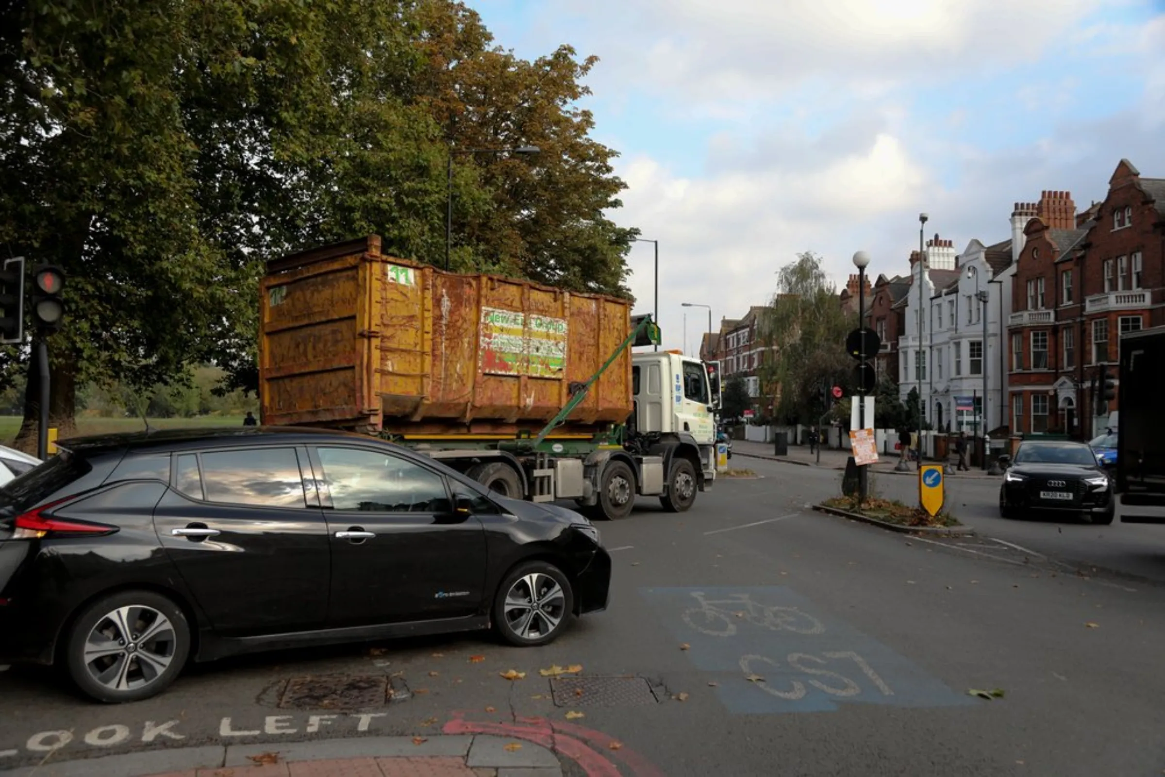 An electric car navigates a busy road junction in Clapham South, a south London district known for its challenging-to-retrofit Victorian terraced houses in London, England, on October 19, 2021