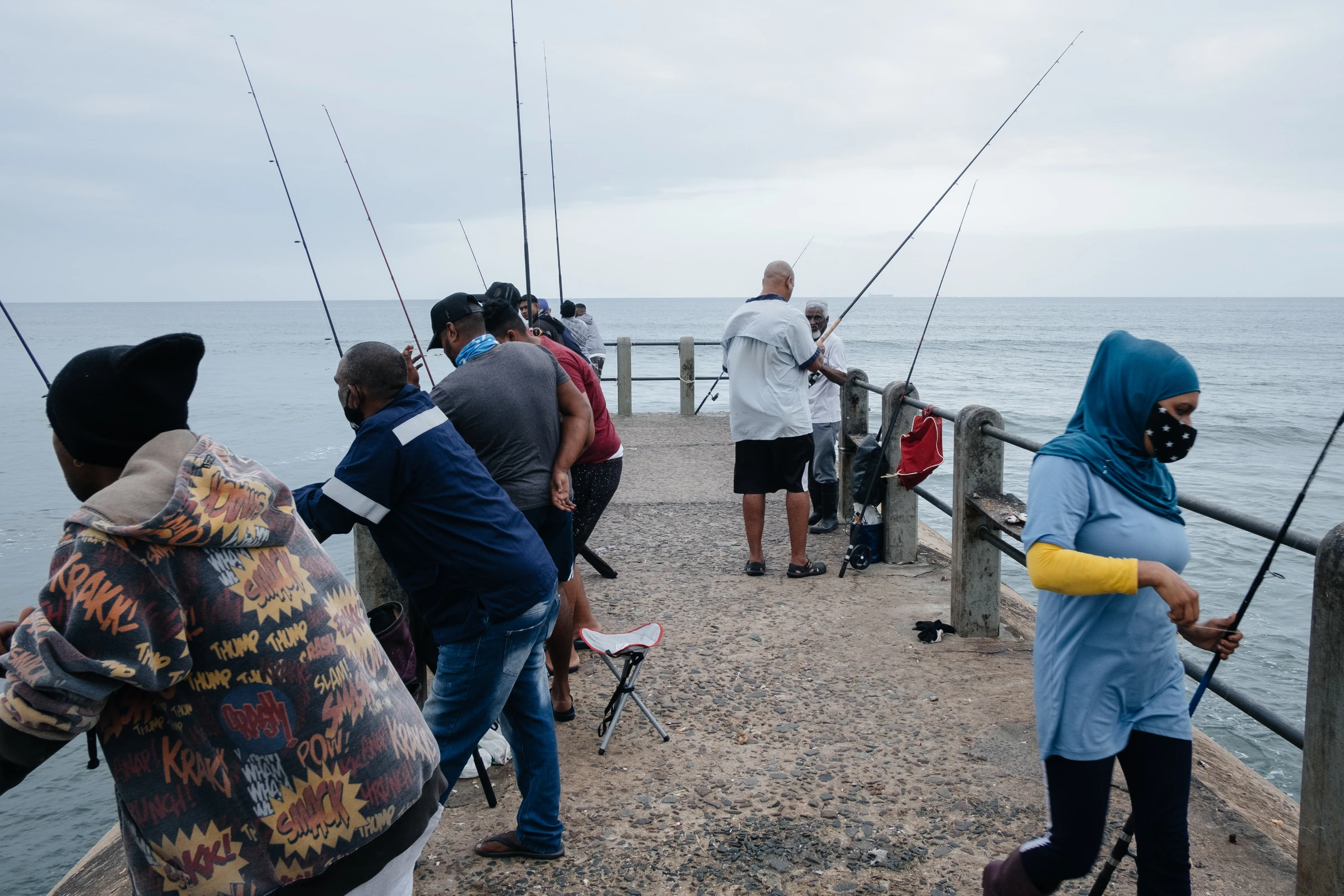 Subsistence anglers look for a catch at Snakepark Pier on the beachfront in Durban, South Africa, April 1, 2021. They fear warming oceans, sea level rise and decreases in the diversity of fish species will hit their catch. Thomson Reuters Foundation/James Puttick