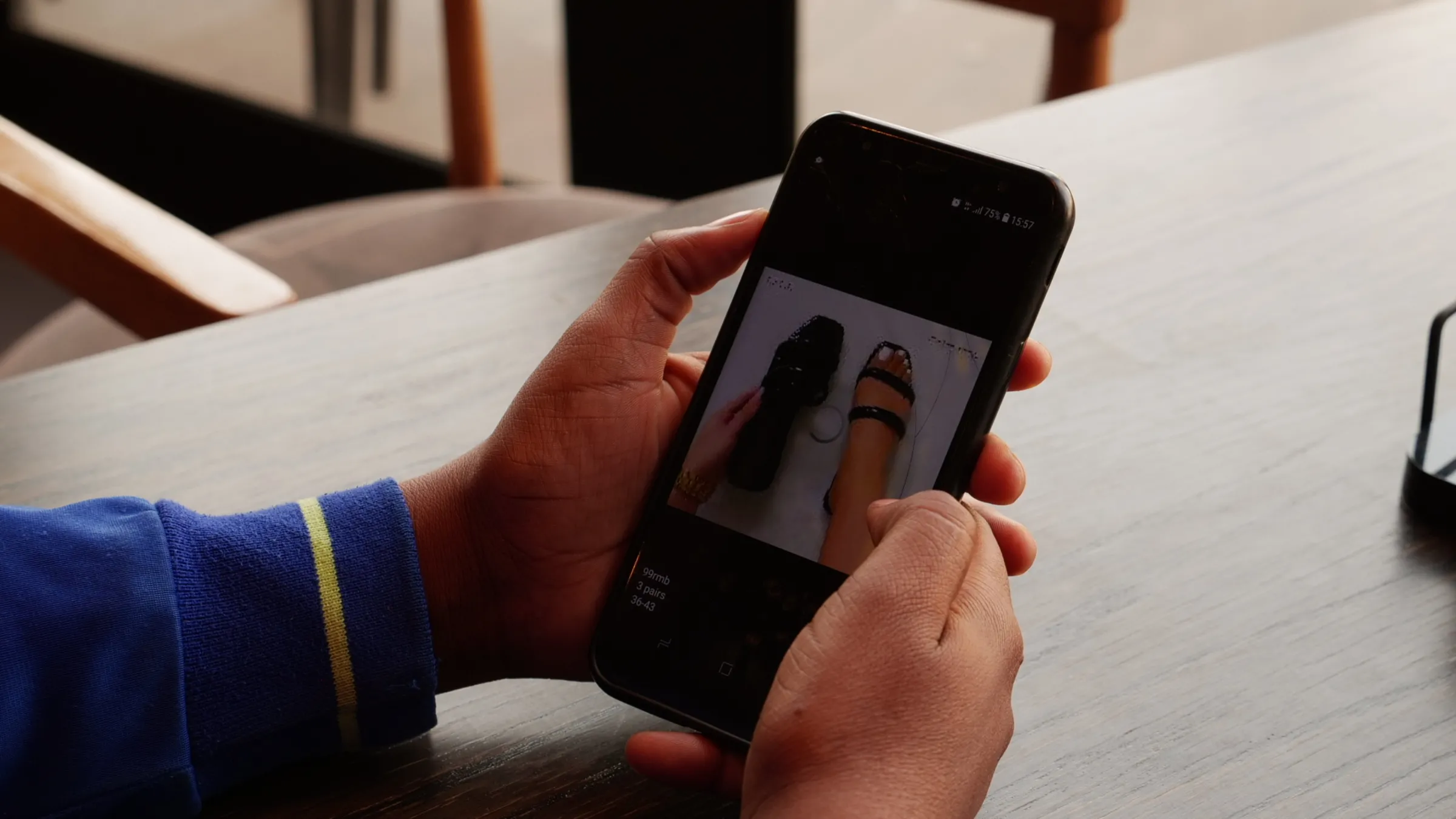 Ruth Lazarus scrolls through images of some of the shoes she is selling online while sitting at a coffee shop in Windhoek, Namibia, September, 24, 2022