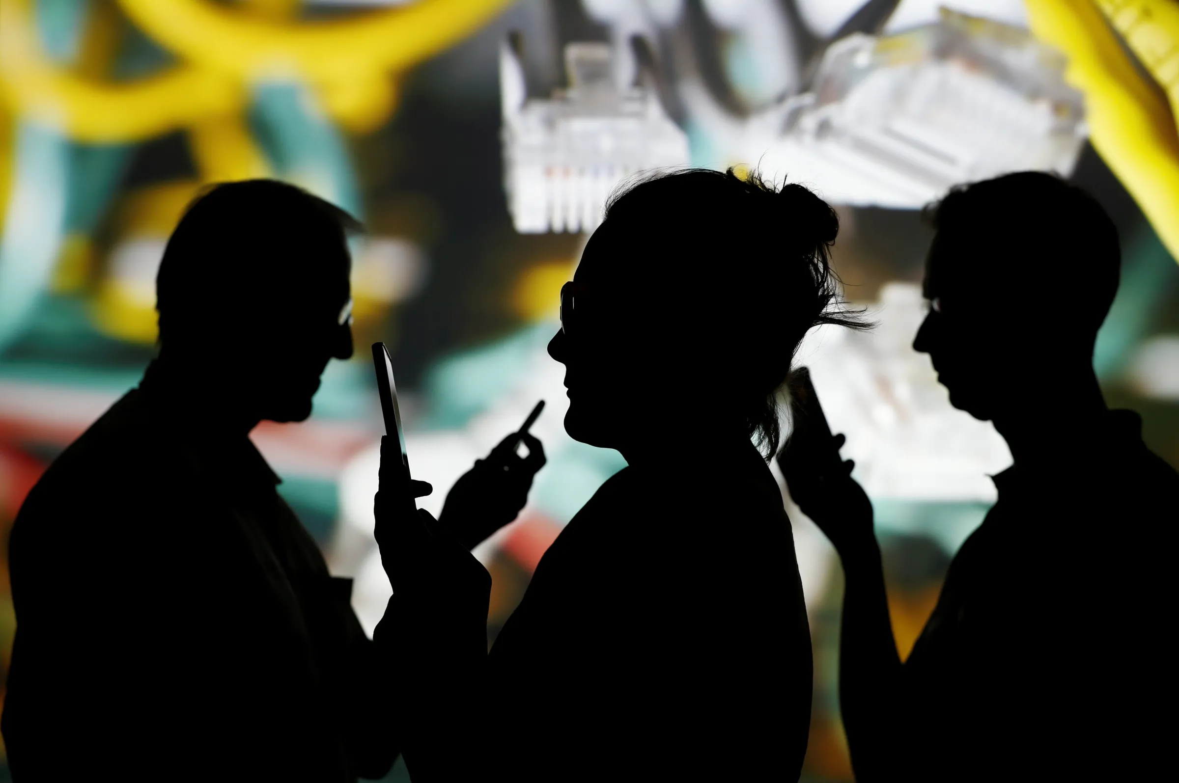 People look at data on their mobiles as background with internet wire cables on switch hub is projected in this picture illustration taken May 30, 2018. REUTERS/Kacper Pempel