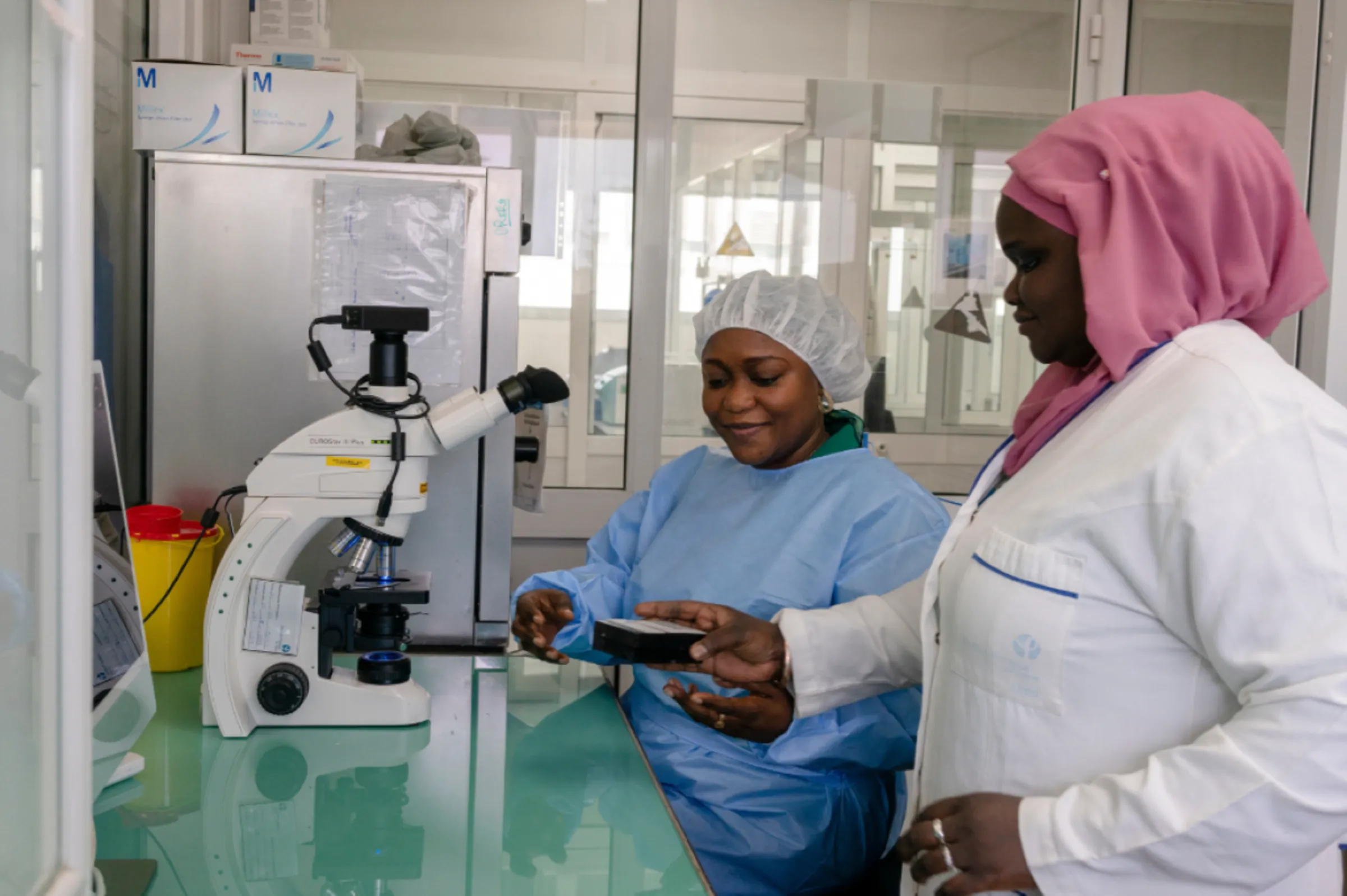 Dr. Gamou Fall (left) and lab technician Arame Ba in the cellular isolation room in the Pasteur institute of Dakar, Senegal, 2023