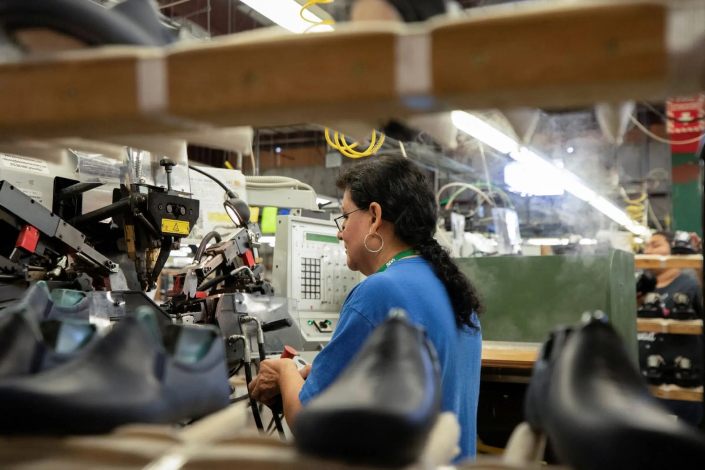 A woman works on the interior mould of a shoe at the San Antonio Shoe Factory in Del Rio, Texas, U.S., April 3, 2023