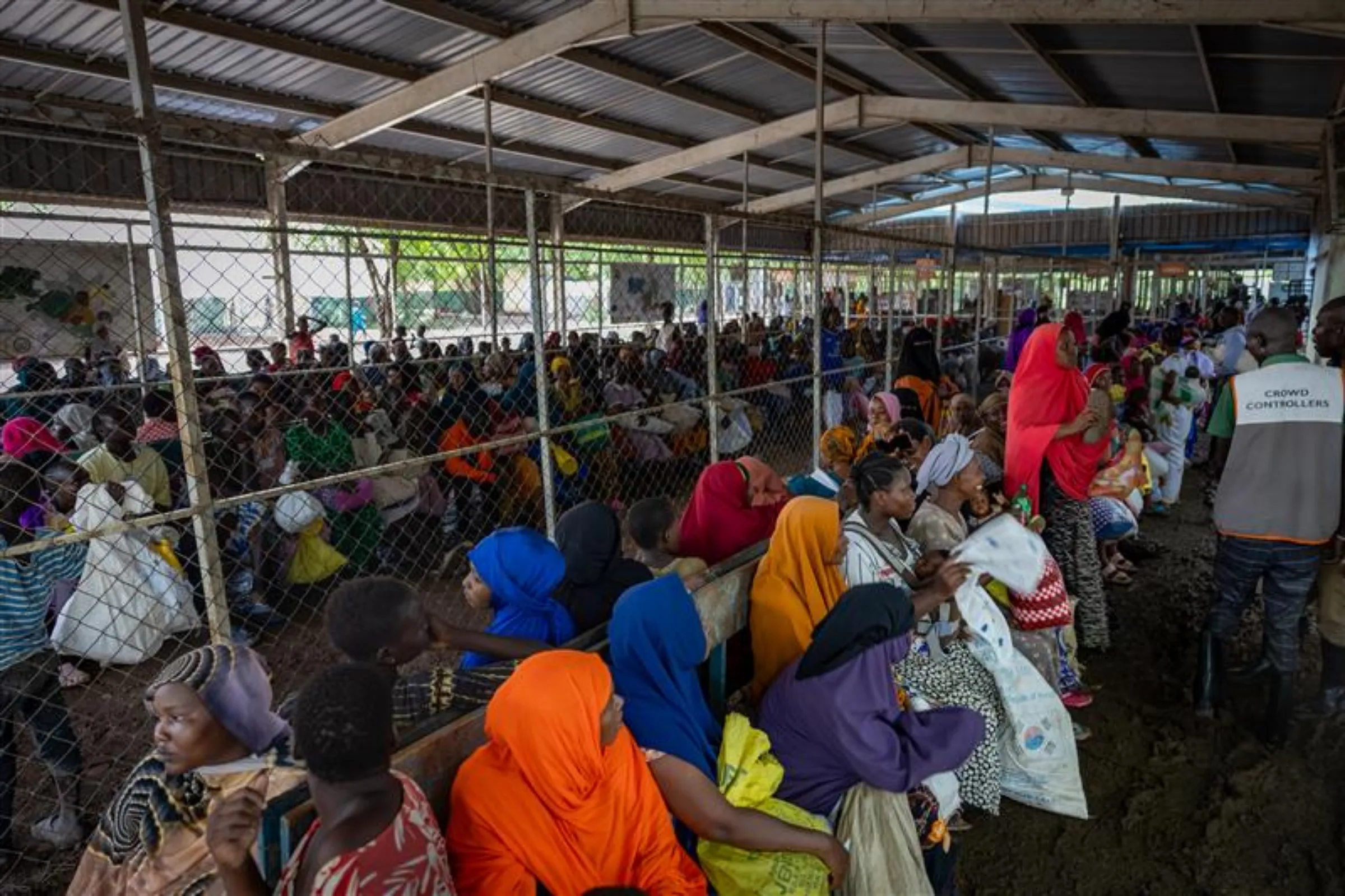A group of refugees sit patiently awaiting their turn to receive their monthly food rations at Kakuma Refugee Camp in Kenya. WFP/Handout via Thomson Reuters Foundation