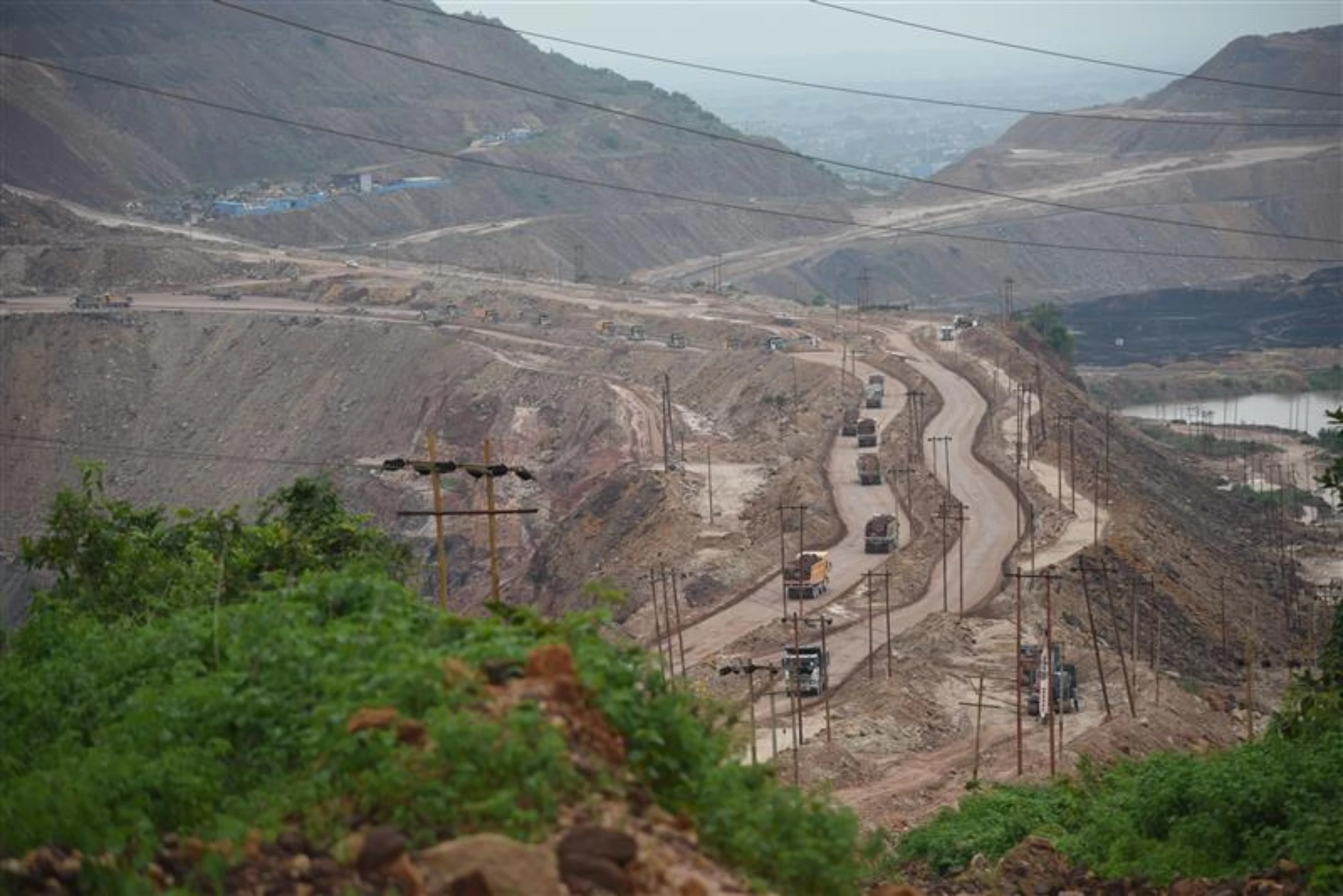 Trucks carrying coal over a road built on mining debri in Singrauli, India, on August 28, 2024. Thomson Reuters Foundation/Tanmoy Bhaduri
