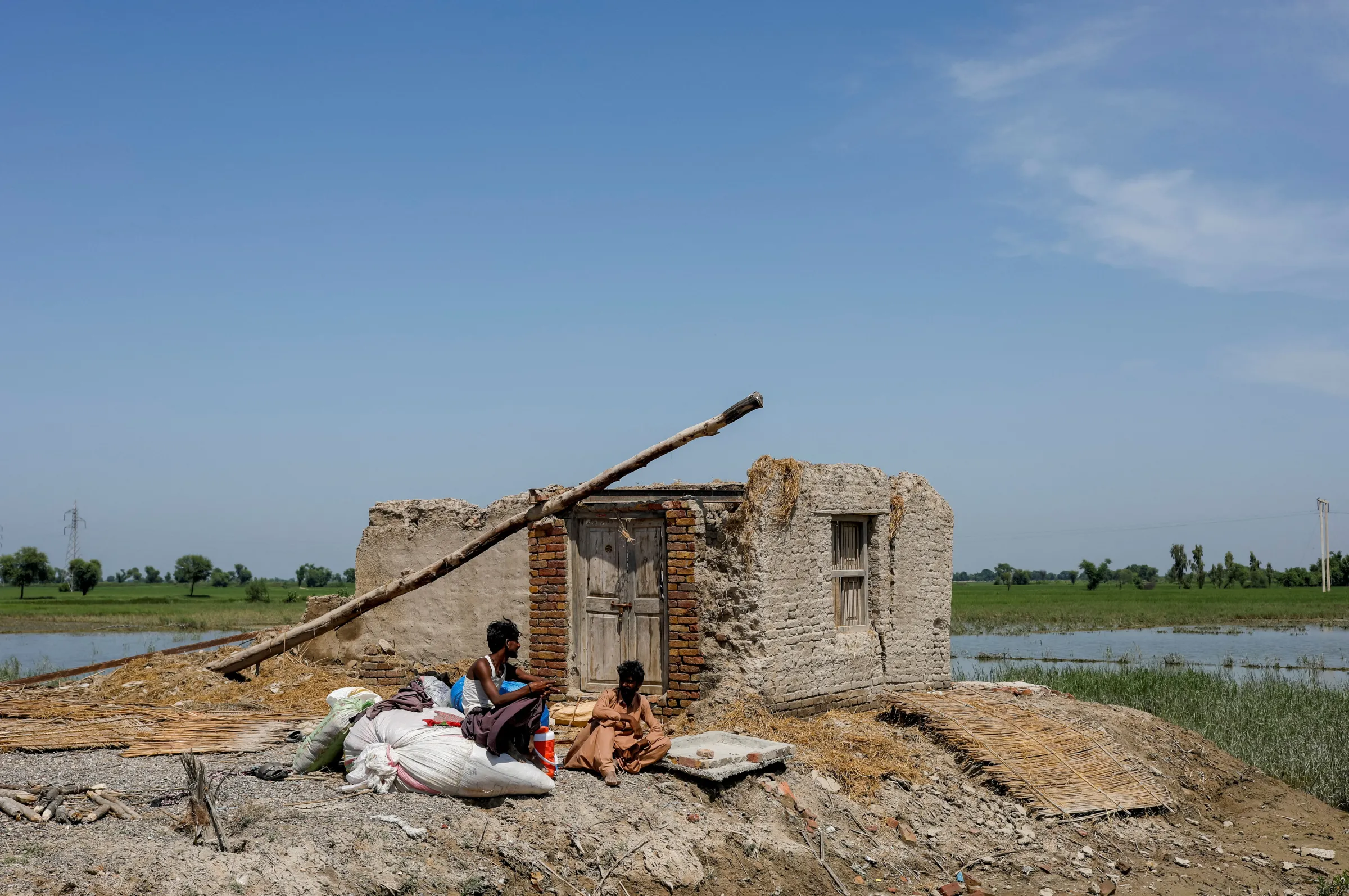 Flood victims sit outside their damaged house, following rains and floods during the monsoon season in Mehar, Pakistan August 31, 2022. REUTERS/Akhtar Soomro