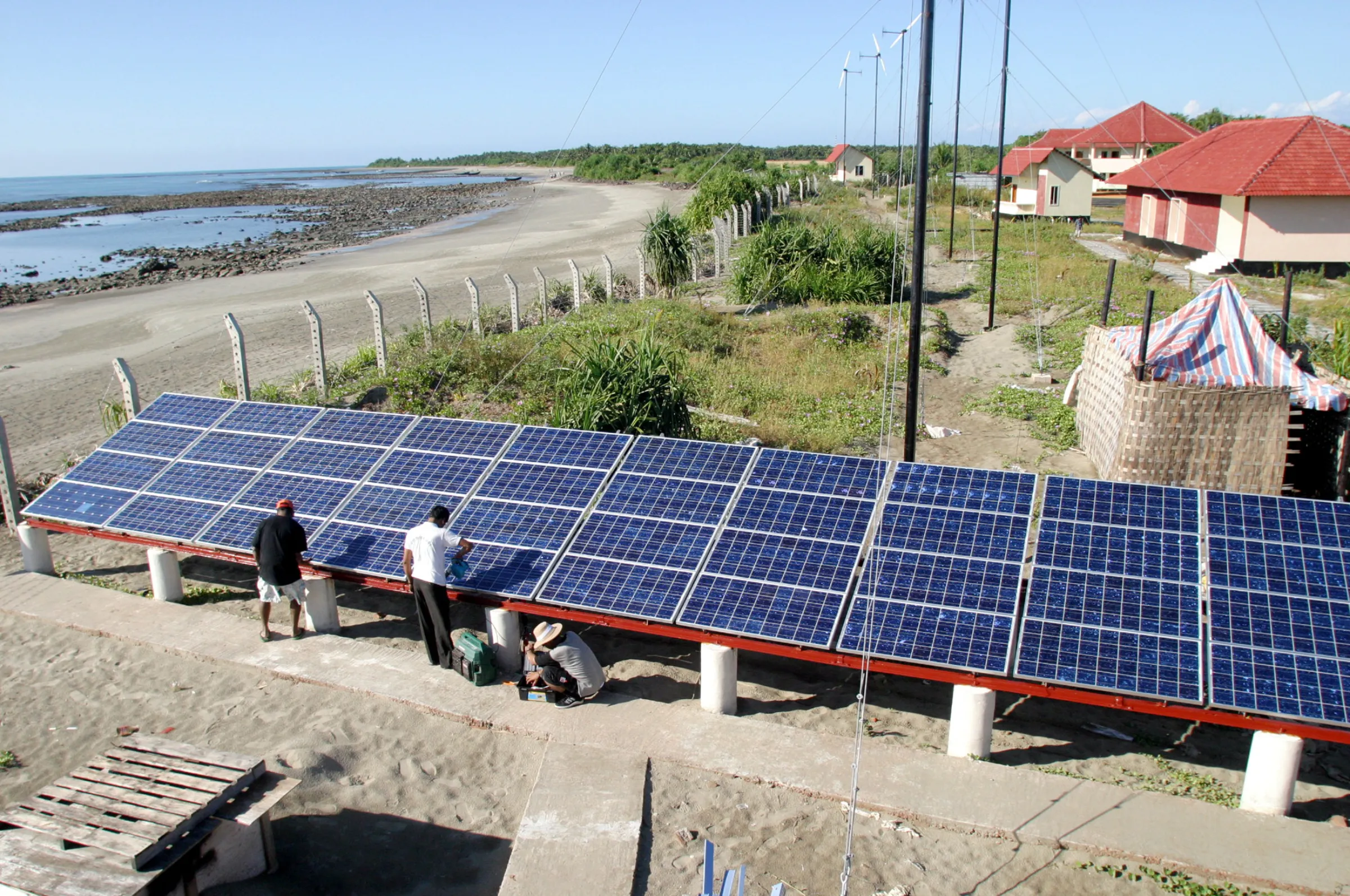 Bangladeshi experts fix a solar panel