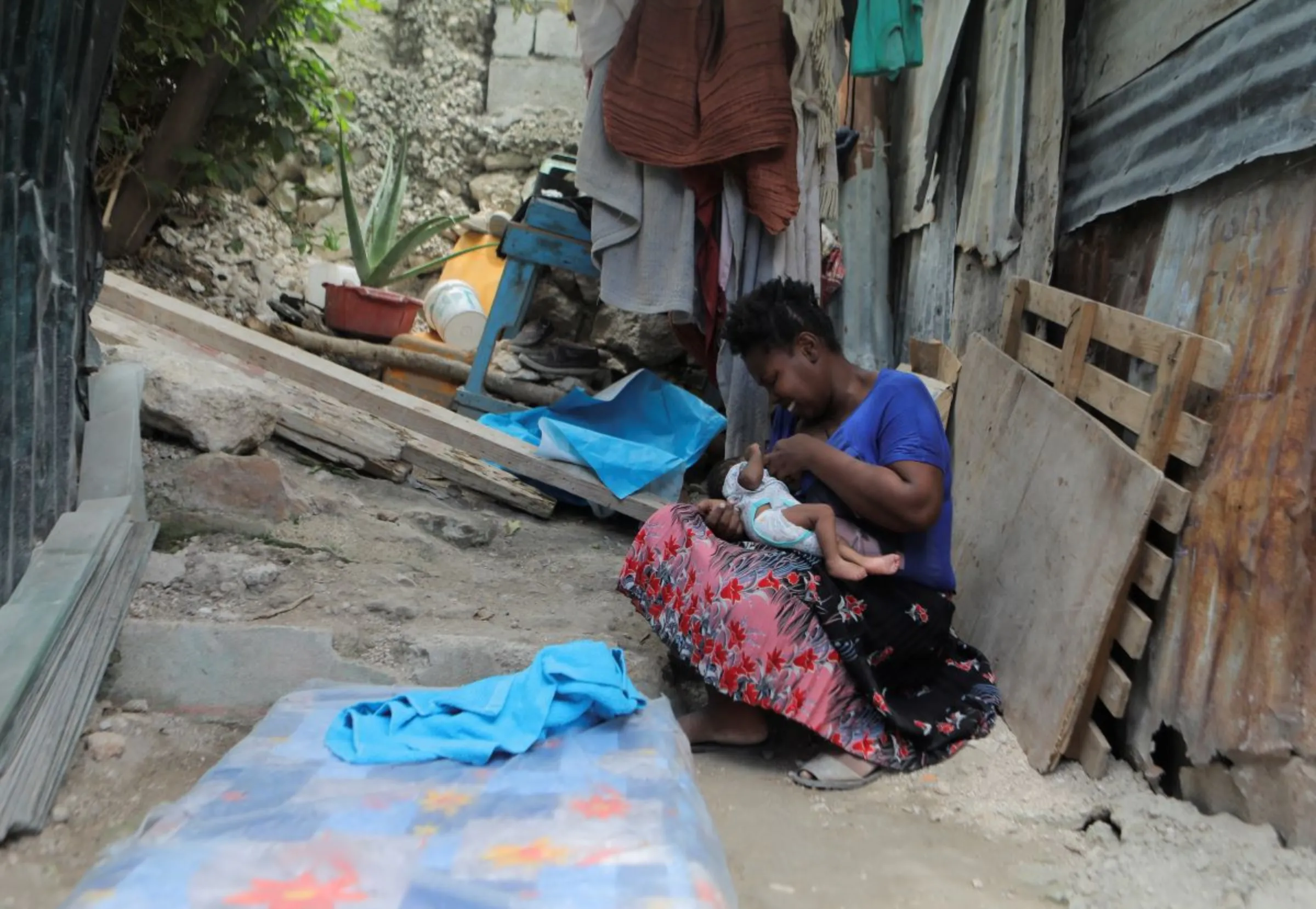 A woman smiles while feeding her baby at the New Church of God of Deliverance camp for displaced people, in Port-au-Prince, Haiti June 19, 2023