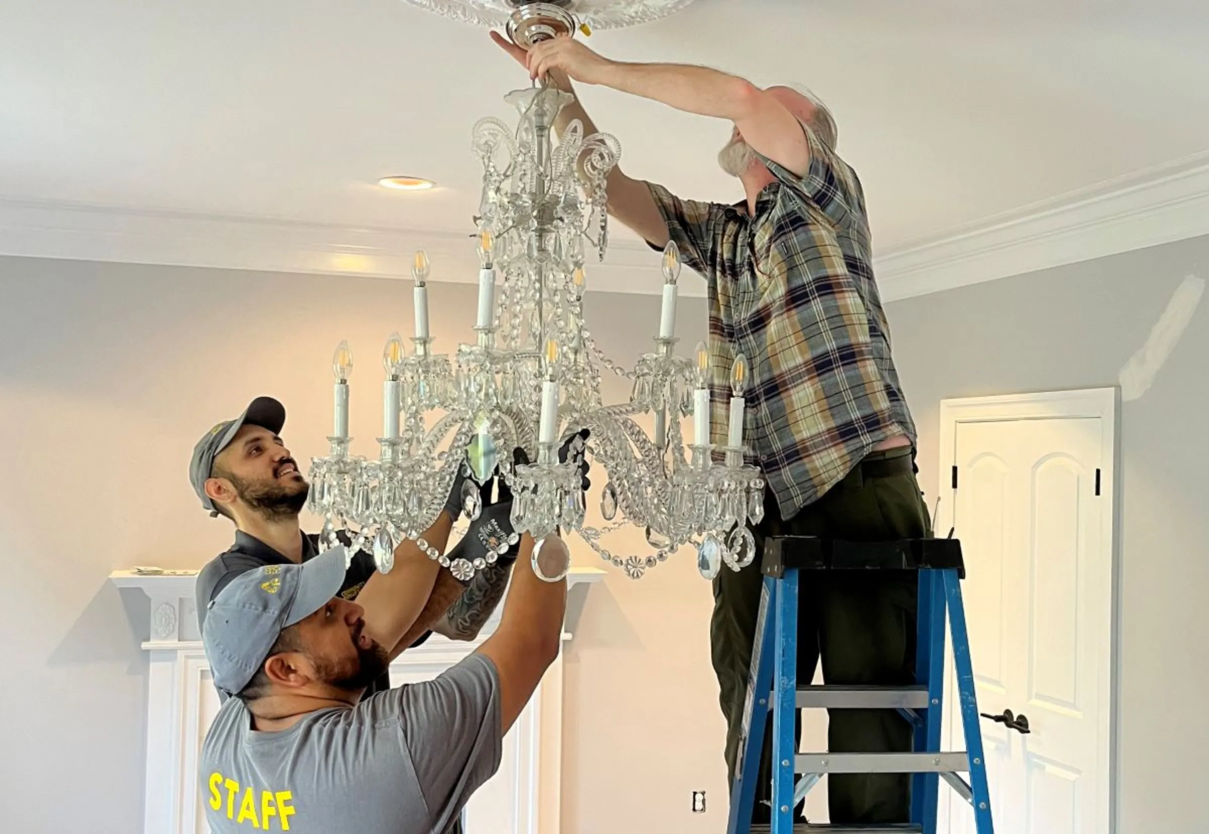 Deconstruction workers remove a chandelier from a home in Potomac, Maryland, in April 2023. Community Forklift/Handout via Thomson Reuters Foundation
