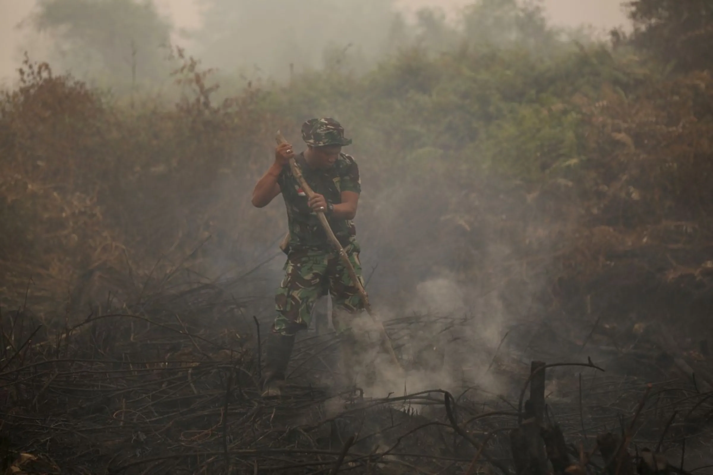 An Indonesian soldier checks on a peat land fire near Palangkaraya, central Kalimantan, Indonesia October 28, 2015. REUTERS/Darren Whiteside