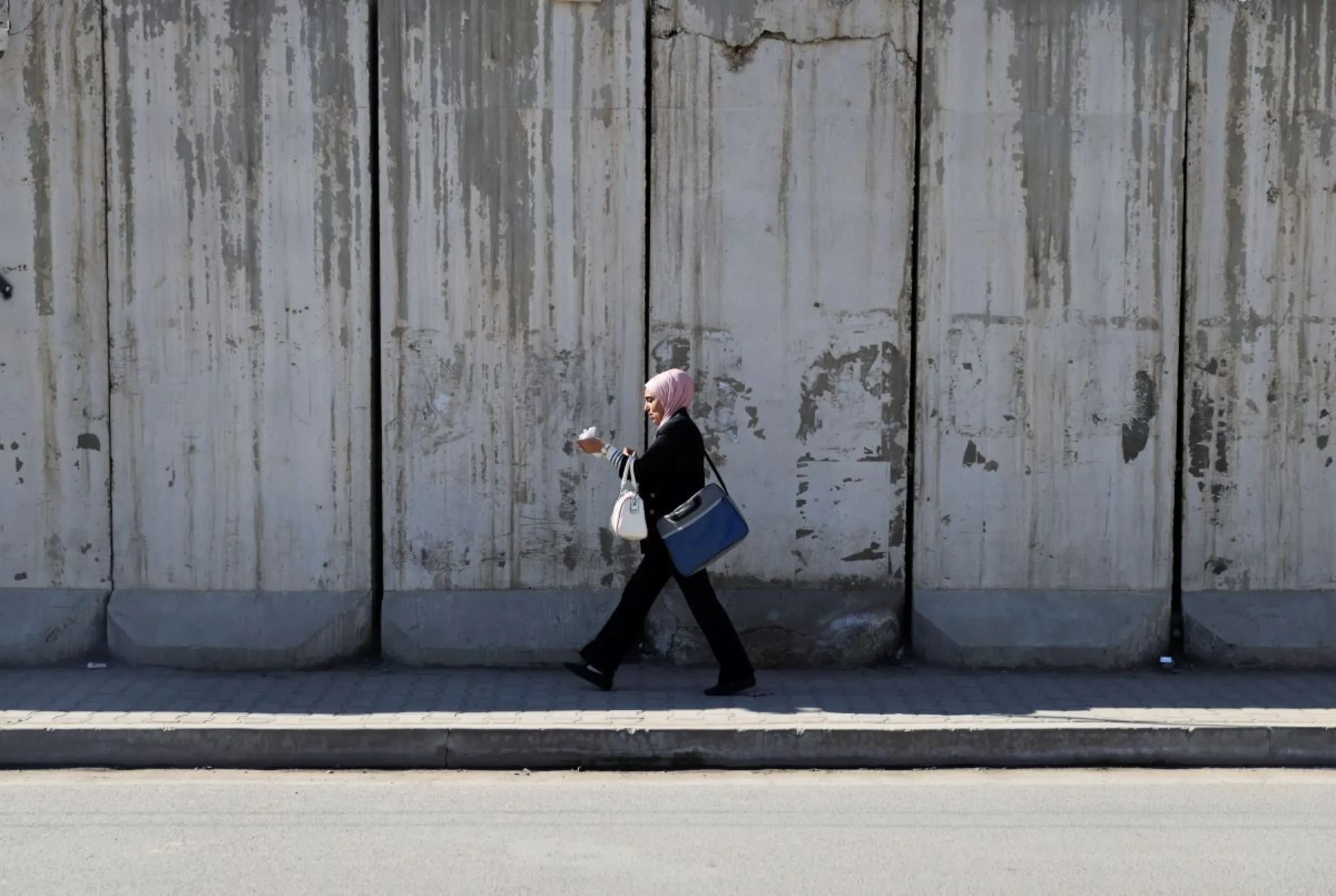 A women walks past Iraq's Health Ministry, Baghdad, Iraq, February 1, 2023. Thomson Reuters Foundation/Abdullah Dhiaa al-Deen.