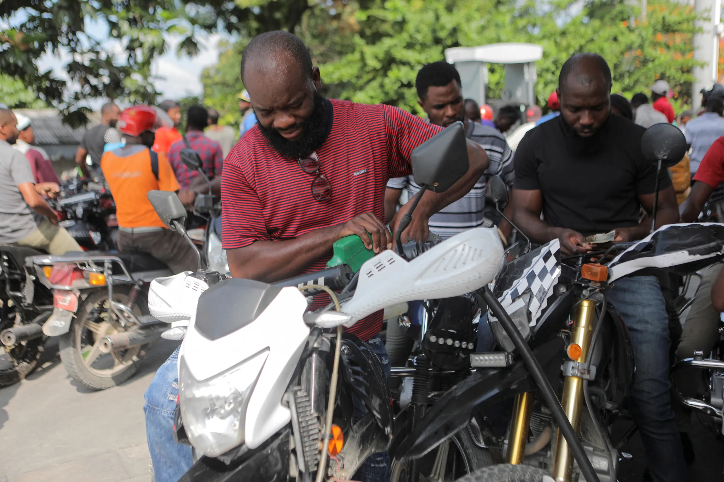 Vehicle owners fill their tanks at a petrol station as Haiti resumes fuel supplies after police break a two-month gang blockade that left the economy without petrol or diesel and sparked a humanitarian crisis, in Port-au-Prince, Haiti November 12, 2022. REUTERS/Ralph Tedy Erol