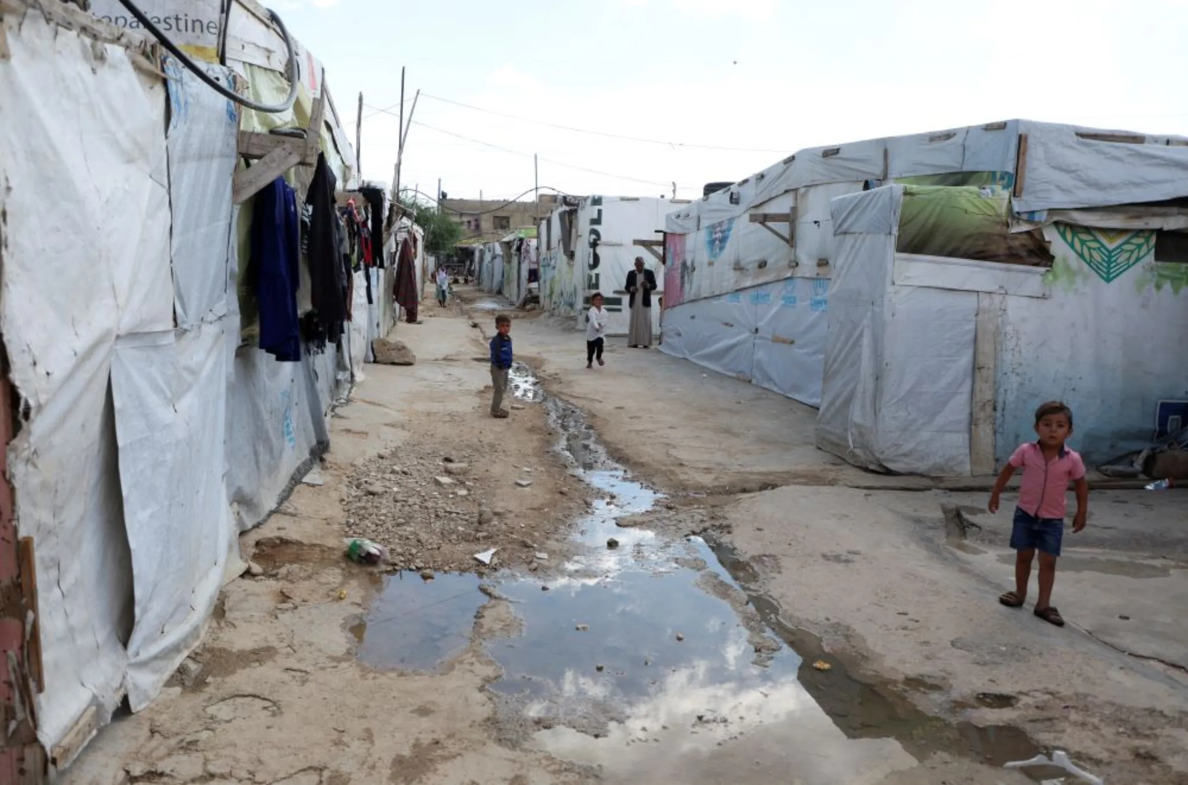 Syrian refugee children stand near water way at an informal camp in Qab Elias, in Lebanon's Bekaa Valley October 18, 2022. REUTERS/Mohamed Azakir