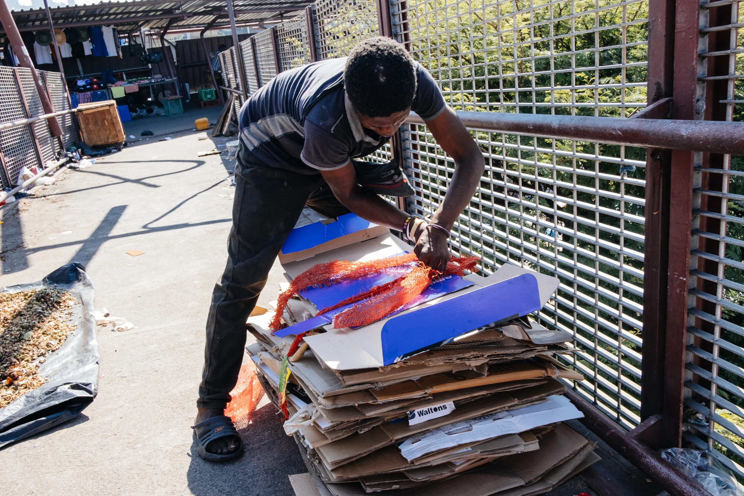 Waste picker Lethukuthula Mnguni, 26, collects cans and cardboard at the Warwick Market in Durban, South Africa, March 31, 2021. Although not formally recognised, Durban's waste pickers help curb climate change by recycling a greater share of the city’s waste. Thomson Reuters Foundation/James Puttick