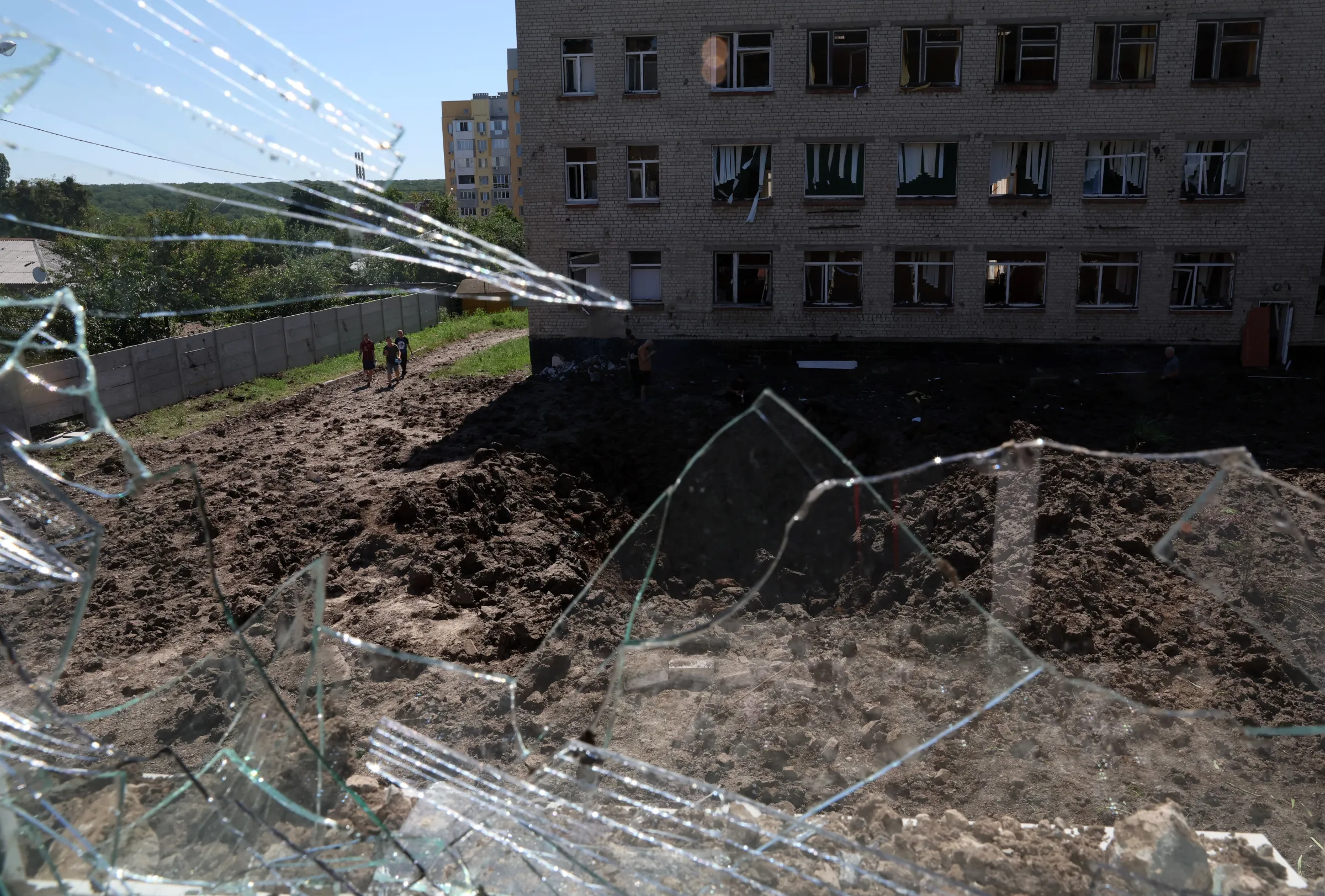 A large crater is visible in a school yard from overnight shelling