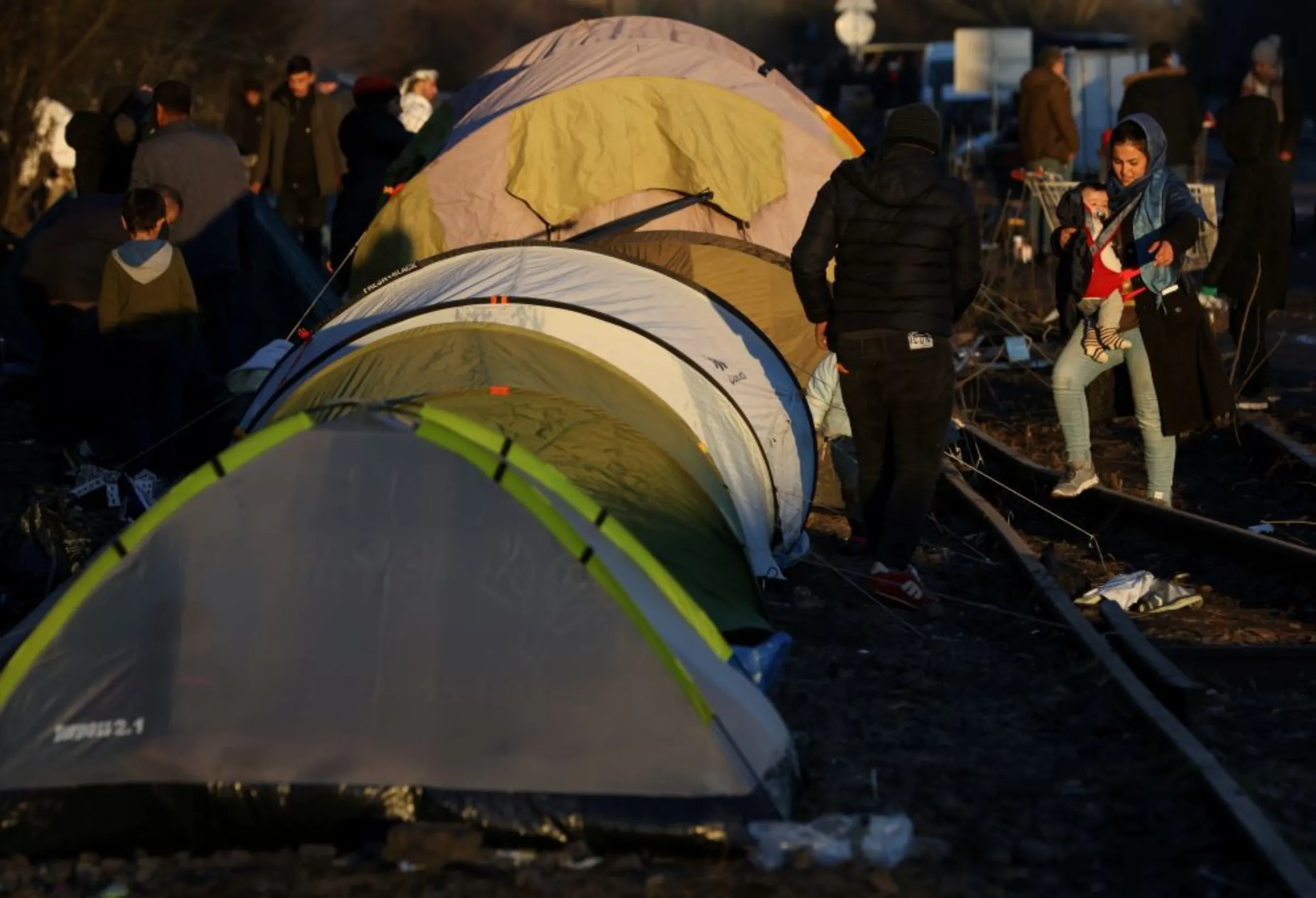Migrants walk at a makeshift migrant camp in Dunkerque near Calais, France, January 13, 2022