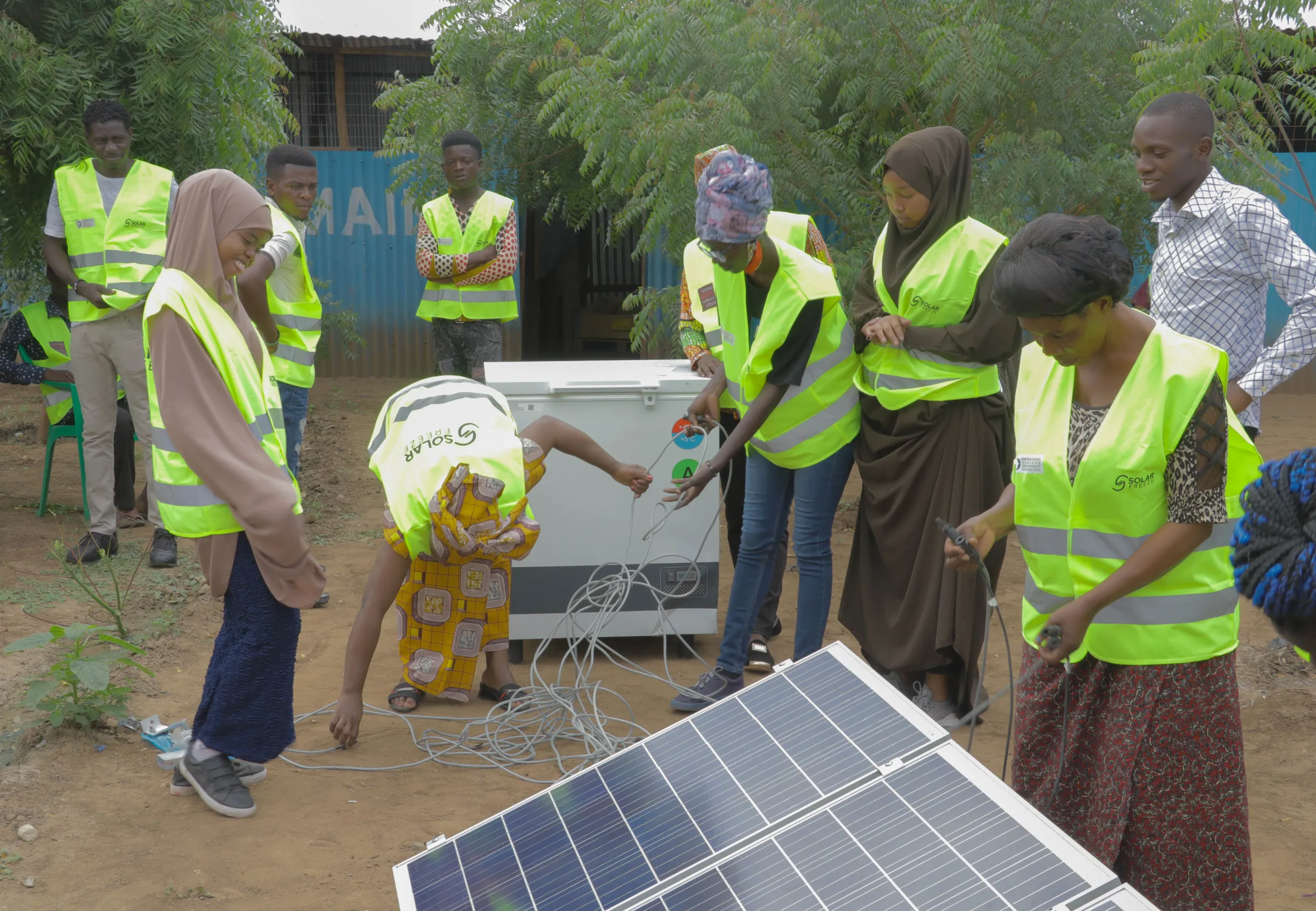 People in high-viz jackets assemble a solar-powered freezer