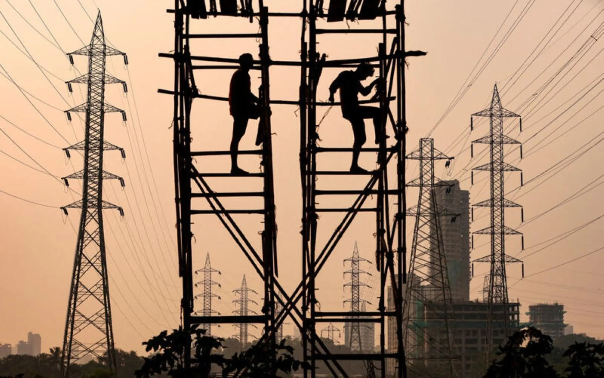 Labourers work next to electricity pylons in Mumbai, India, October 13, 2021. REUTERS/Francis Mascarenhas